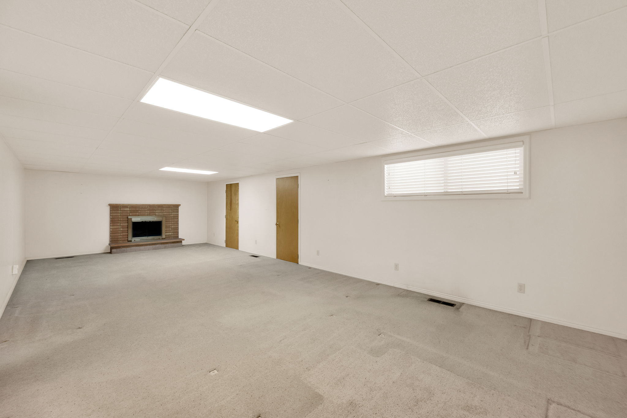 Spacious room featuring a brick-surround fireplace
