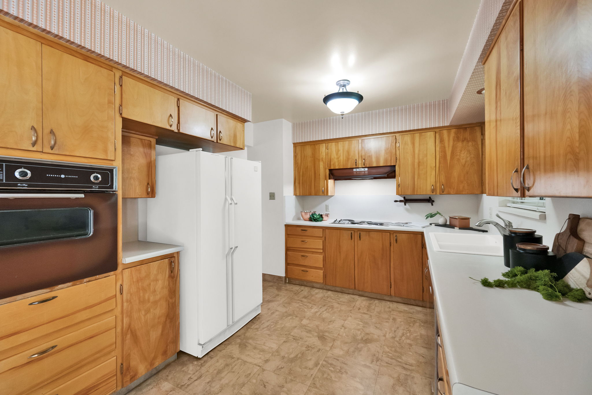 Kitchen featuring built-in oven, refrigerator
