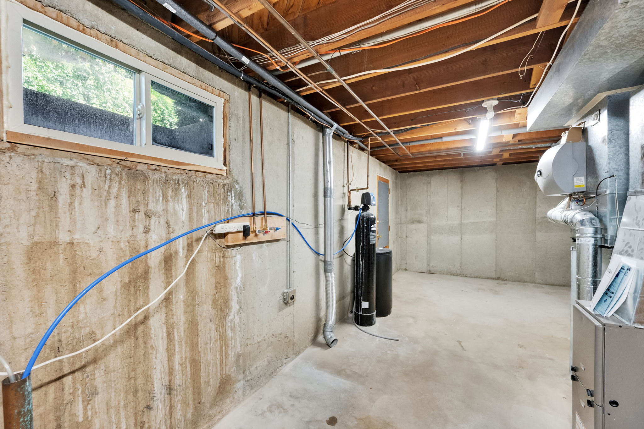 Unfinished basement laundry area, water softener, furnace and water heater. Plumbing for bath