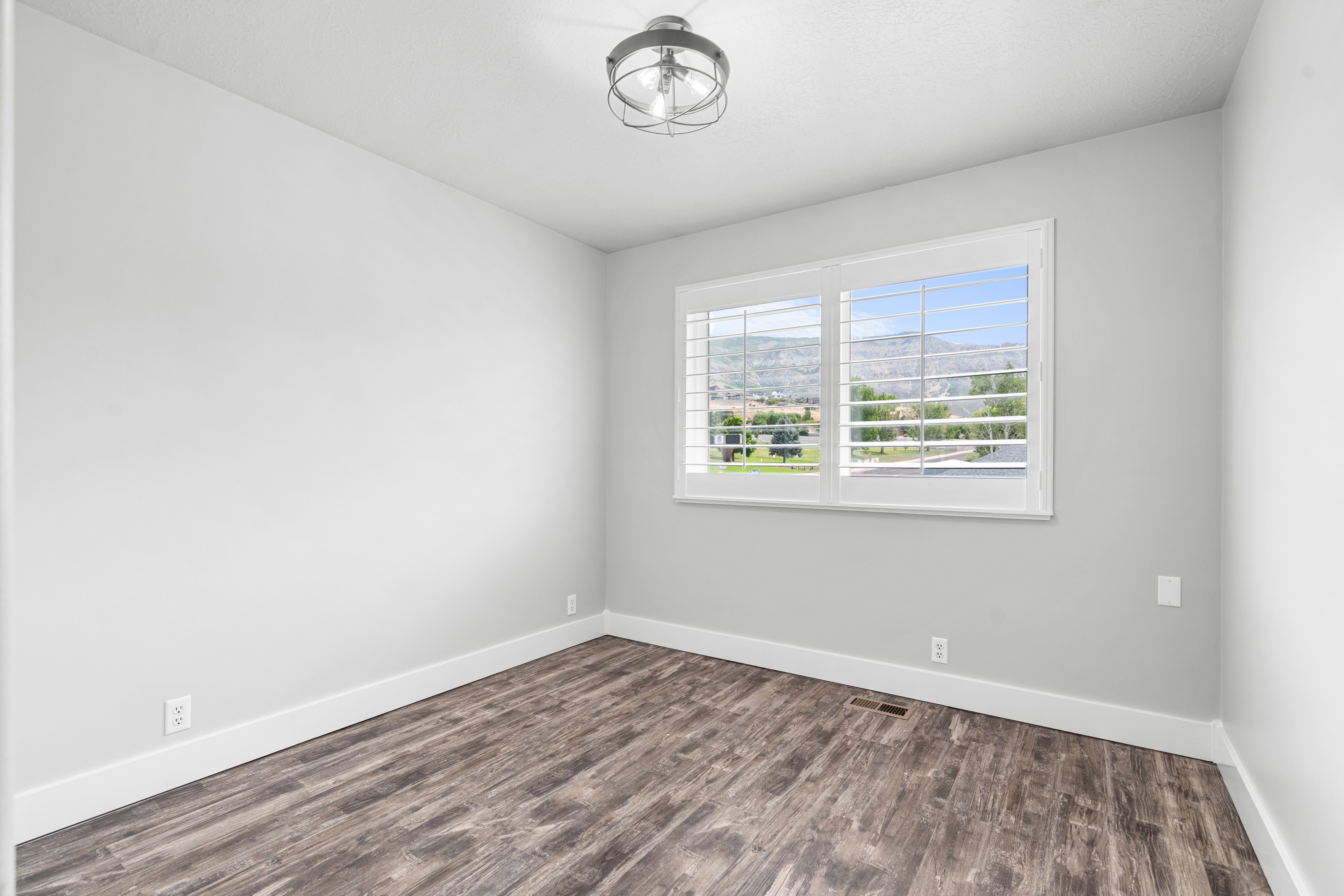 Bedroom featuring LPV flooring, white baseboards, and a contemporary semi-flush mount light fixture