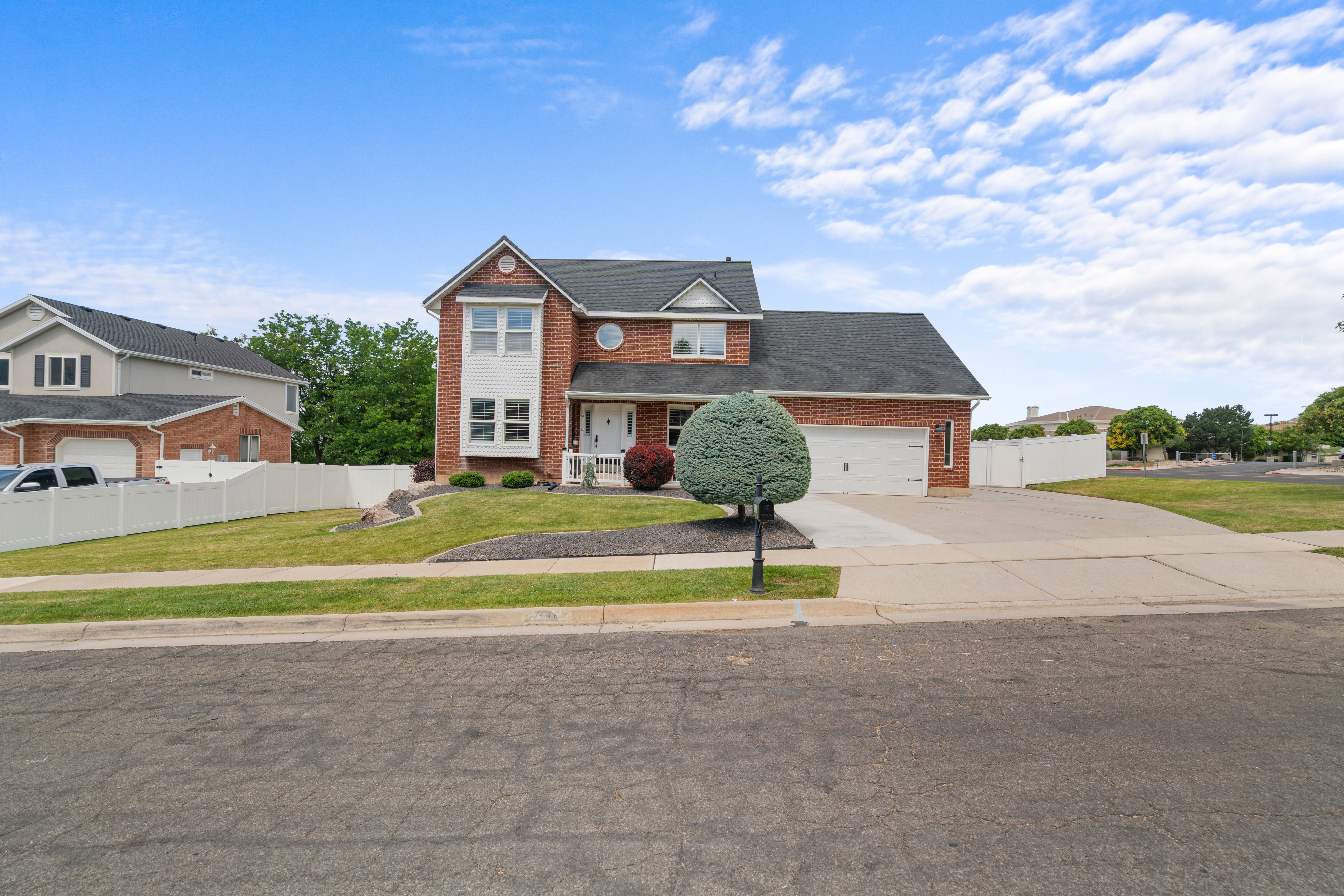 Two-story brick exterior with white trim accents and a dark-shingled roof