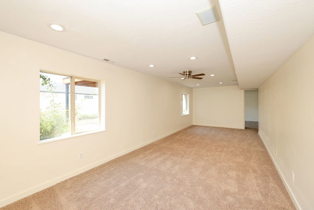 Spacious room with plush carpeting, recessed lighting, and a ceiling fan