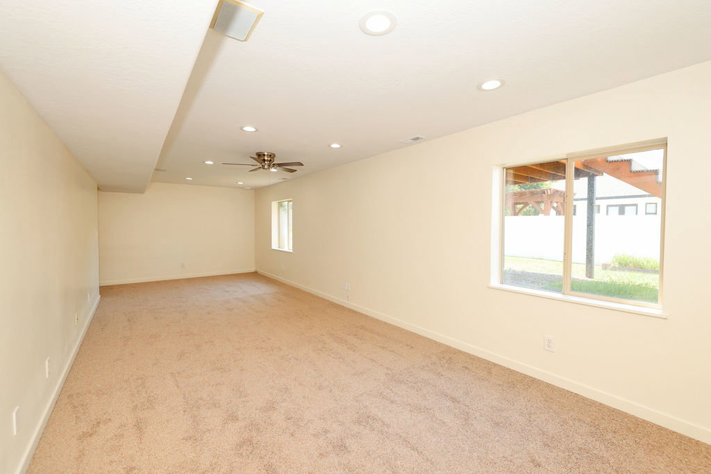 Expansive room featuring recessed lighting, a ceiling fan, a window, and carpet flooring