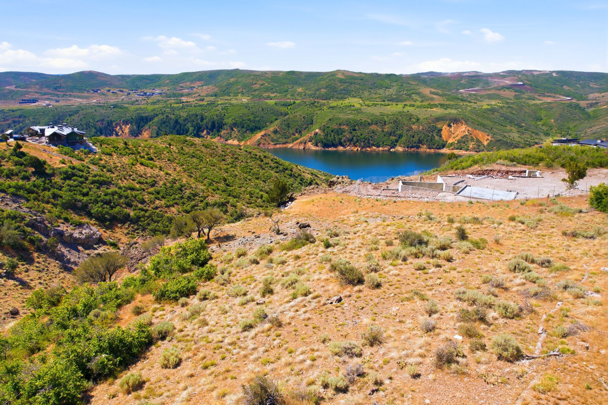 Expansive undeveloped land featuring varied terrain and natural vegetation, offering prominent water frontage