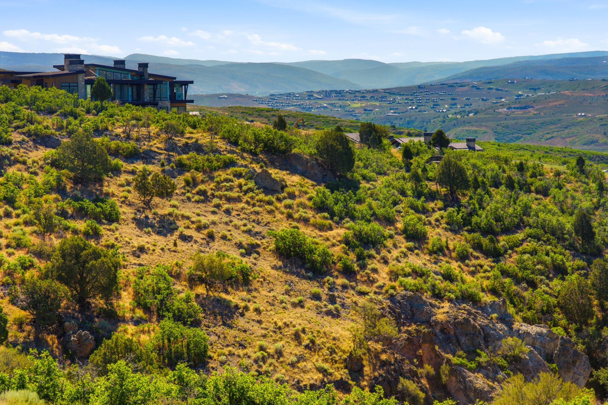 Contemporary mountain-style architecture featuring extensive glass facades, multiple chimneys, and a flat roofline