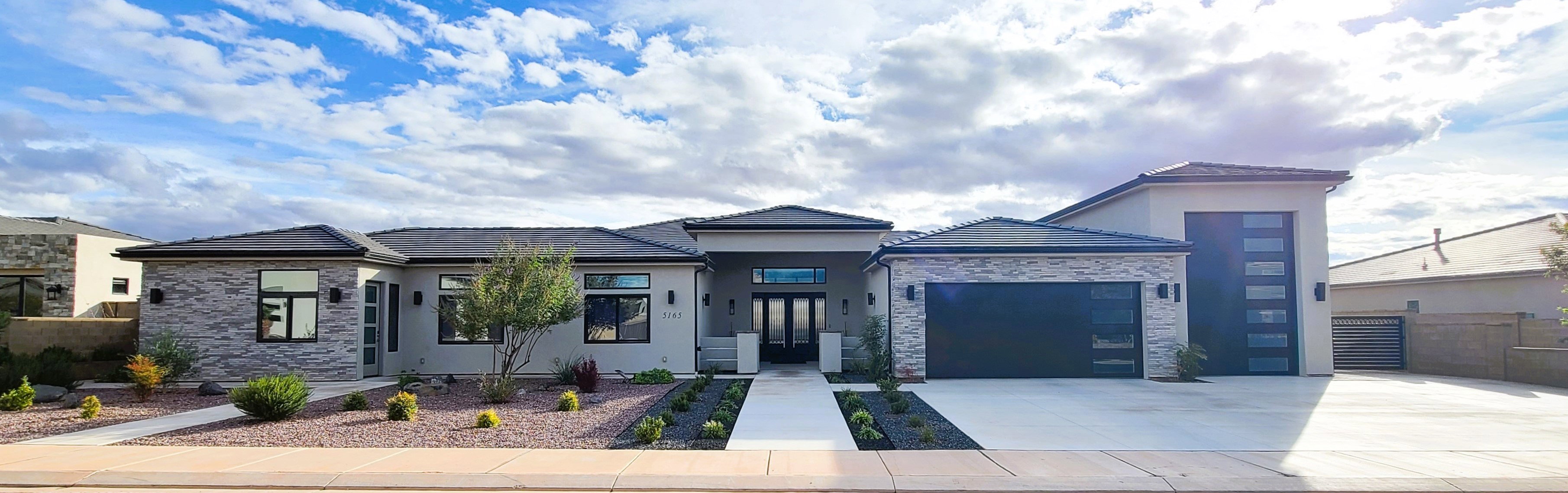 Contemporary exterior featuring stone veneer accents, stucco siding, and a dark tile roof