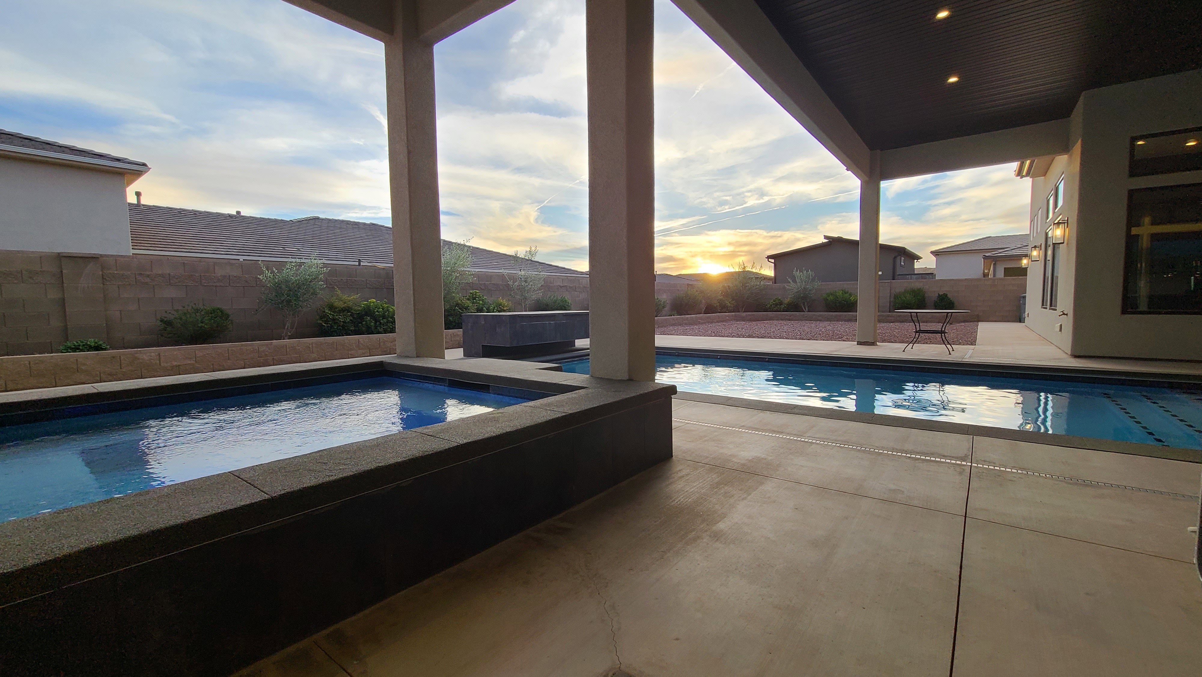 Expansive covered patio featuring a concrete surface, providing a shaded outdoor living area