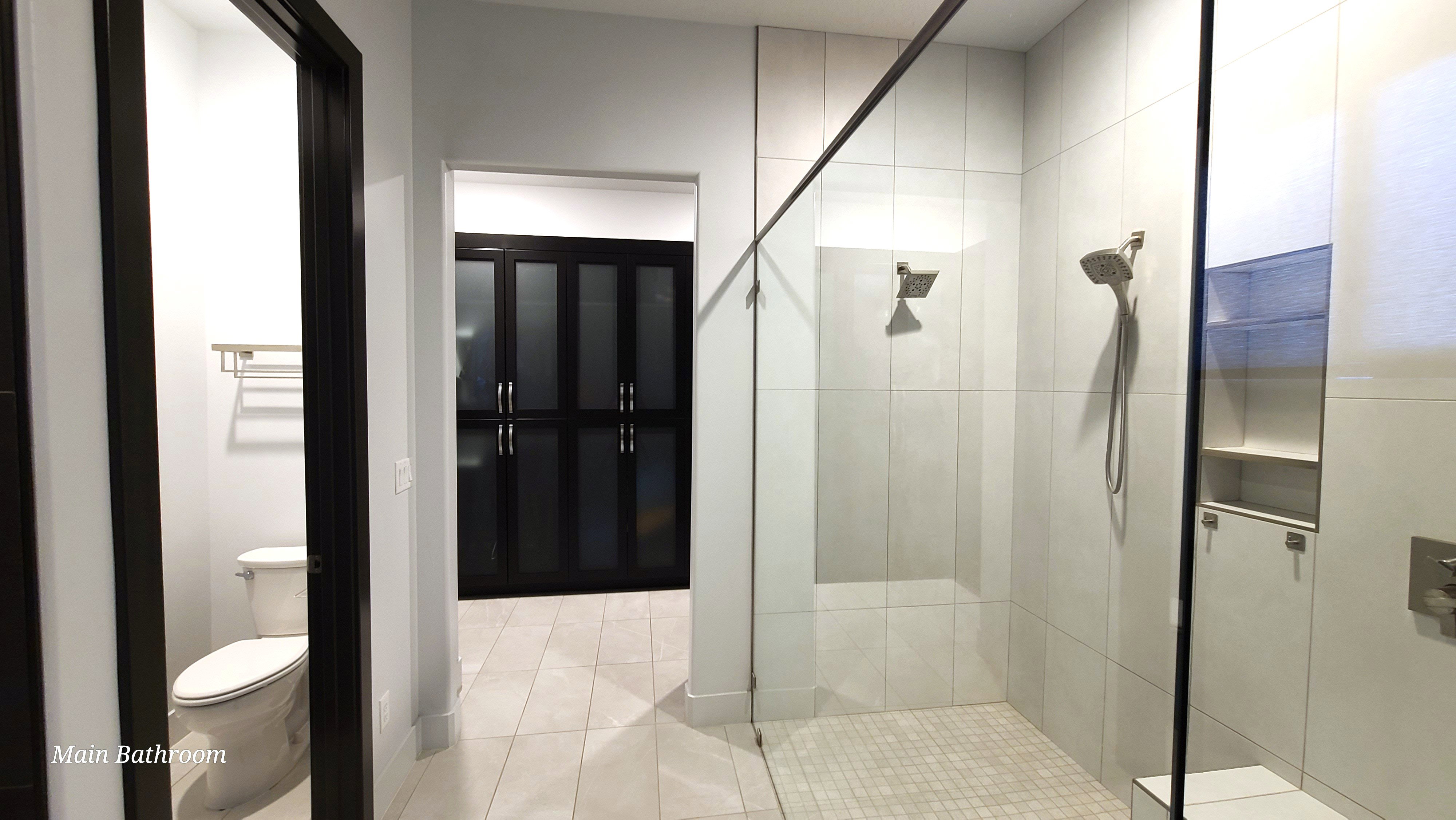 Walk-in shower with clear glass enclosure and dual shower heads