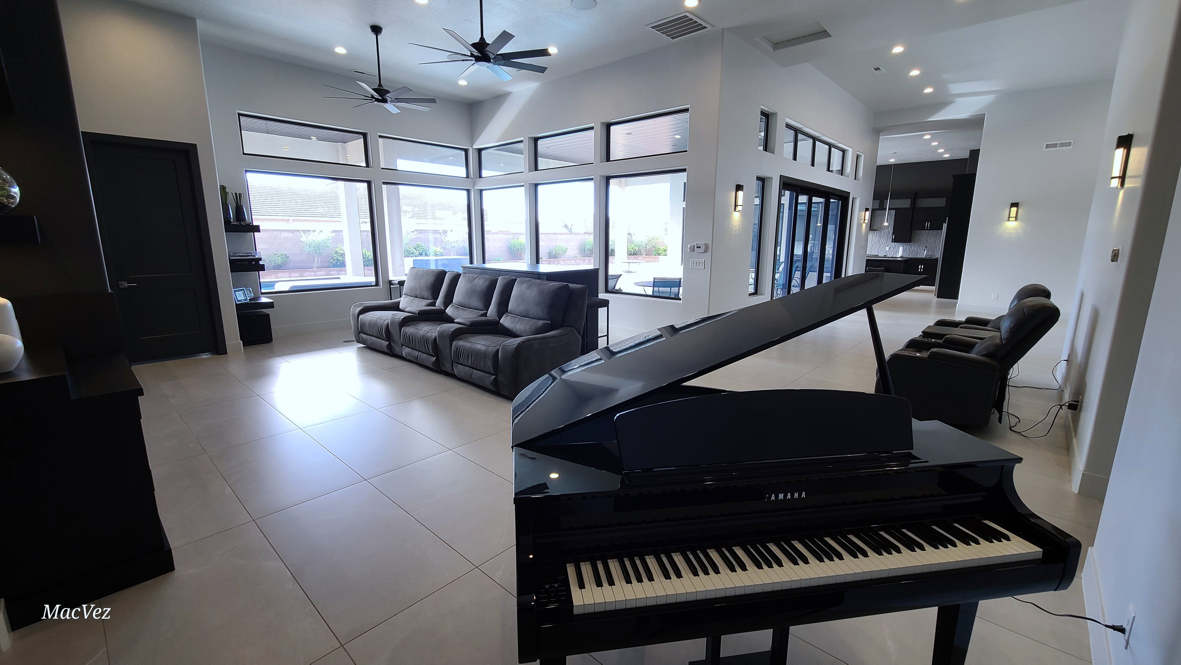 Spacious living area featuring high vaulted ceilings, large format tile flooring, and extensive window-wall fenestration