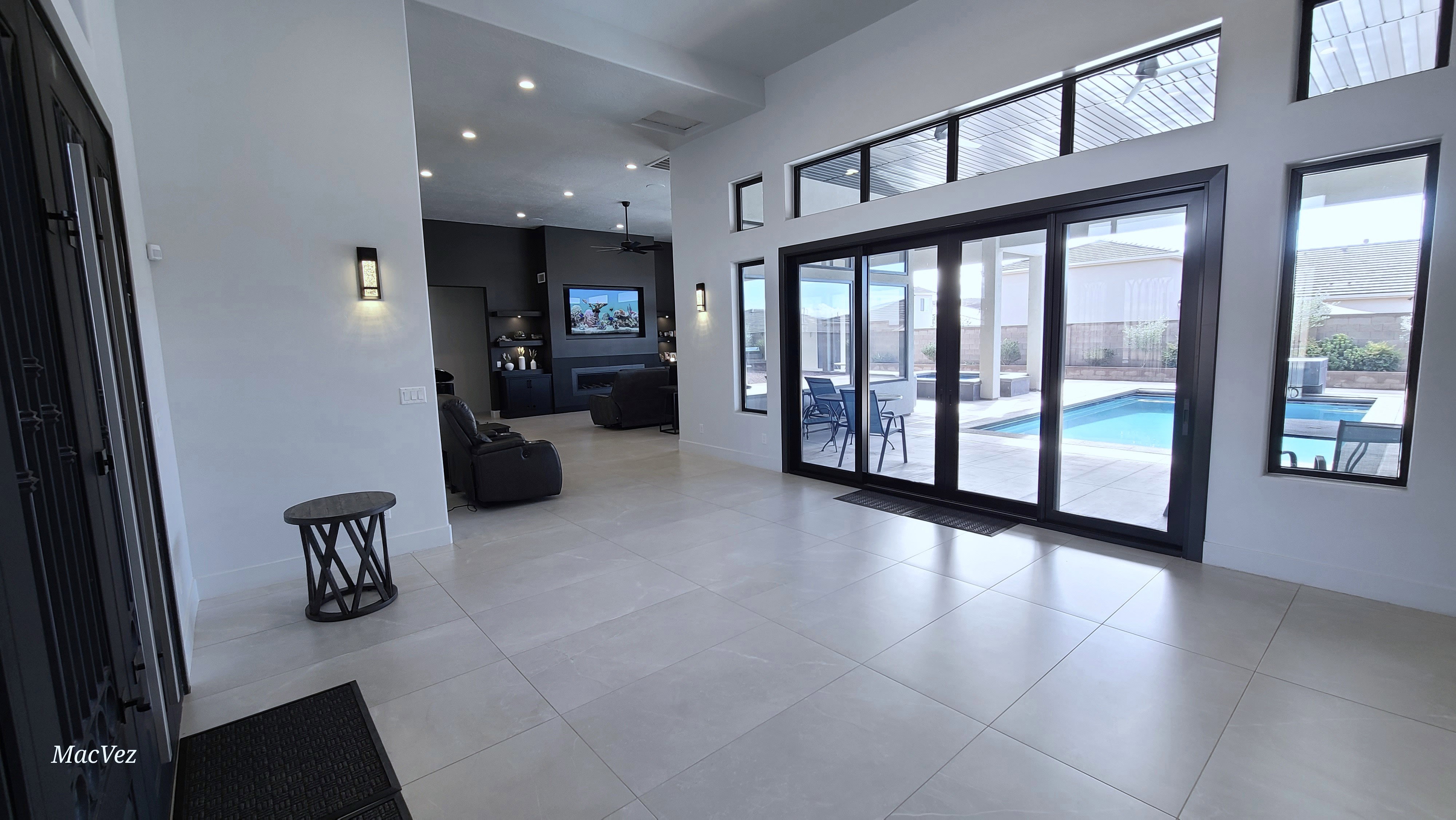 Spacious interior featuring large format tile flooring, recessed lighting, and modern wall sconces