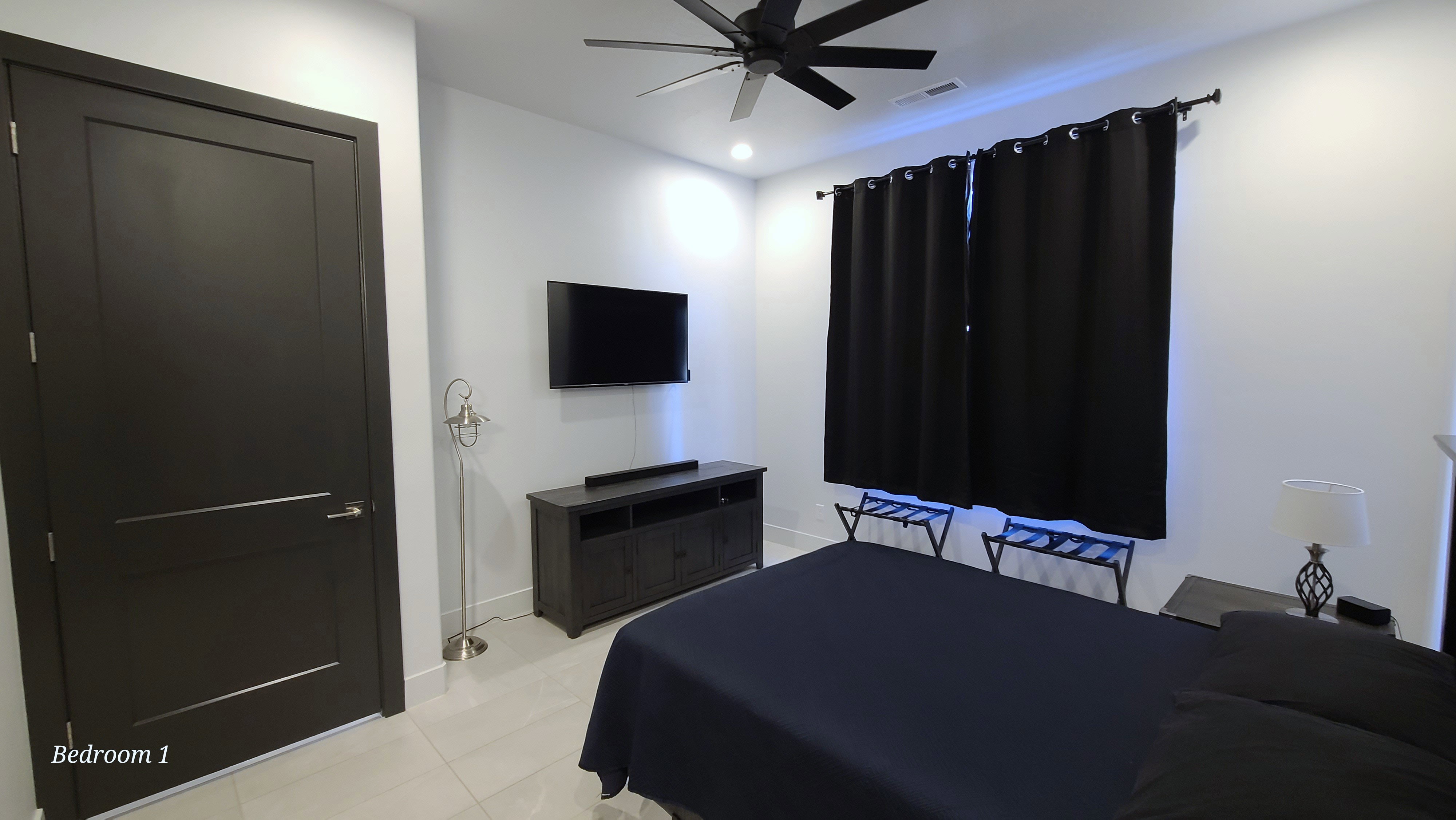 Bright room featuring light-toned tile flooring and a ceiling fan