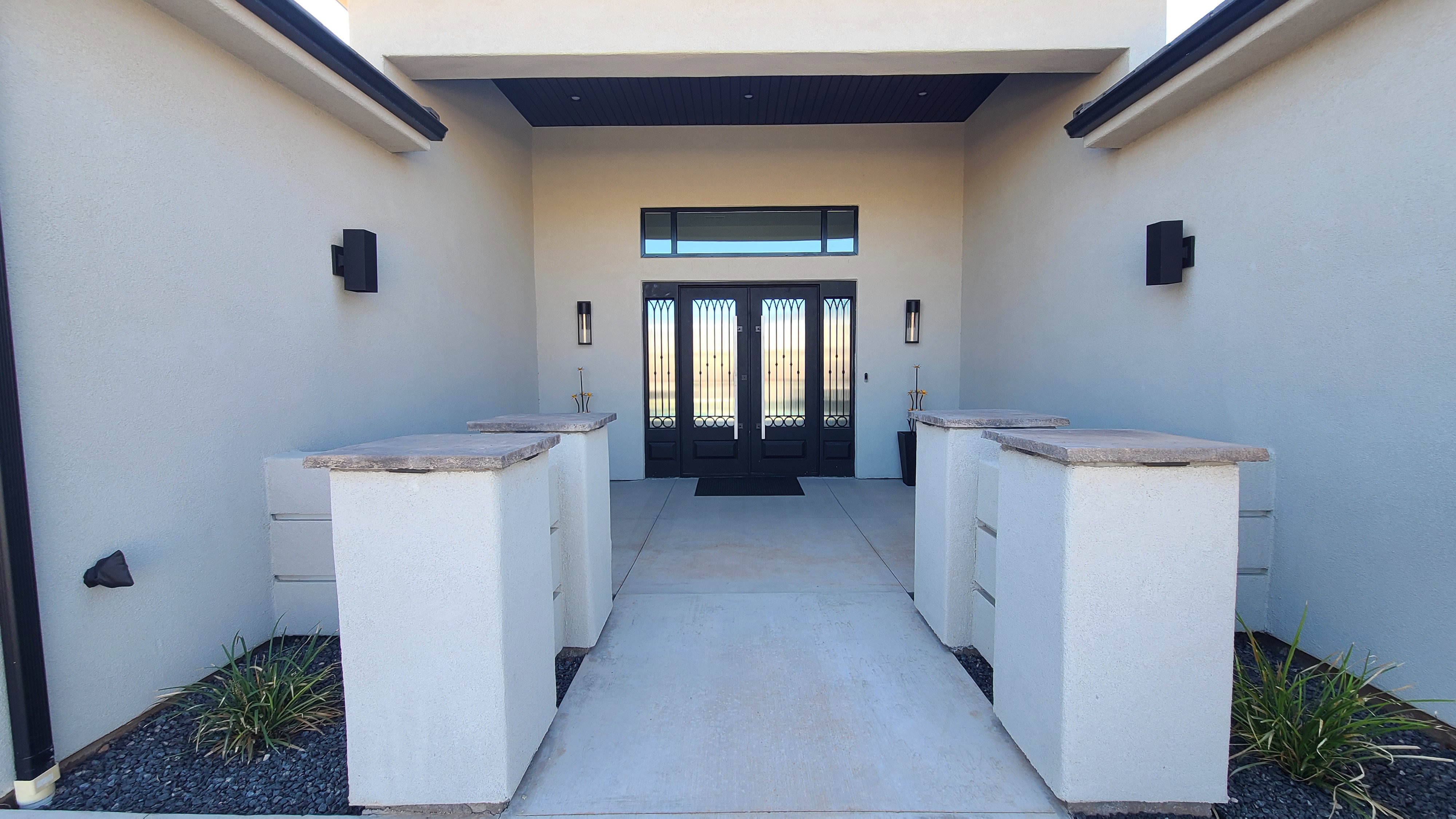 Covered entryway with double iron-paneled doors