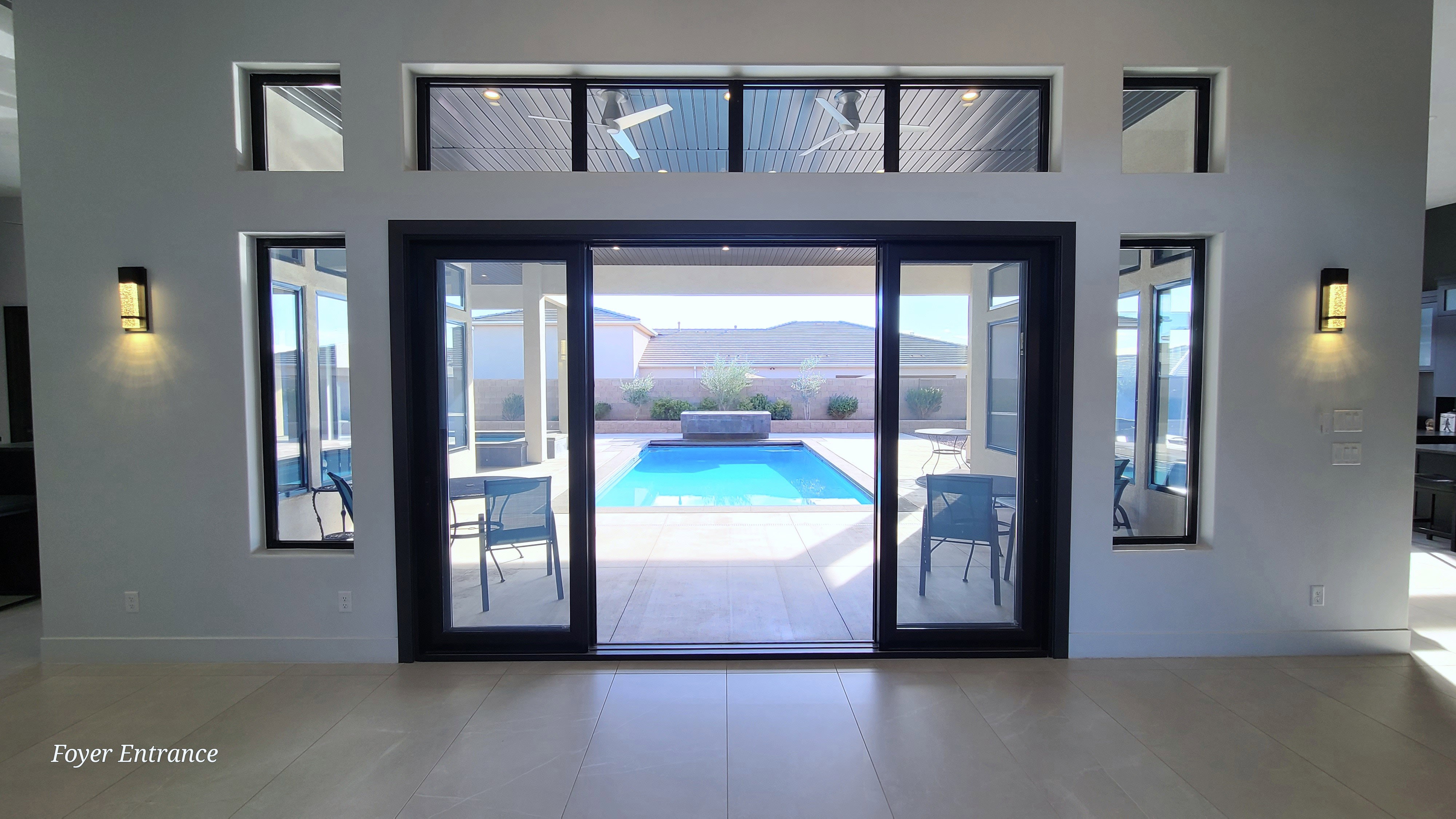 Interior entry space featuring a large sliding glass door, transom windows, and side accent windows
