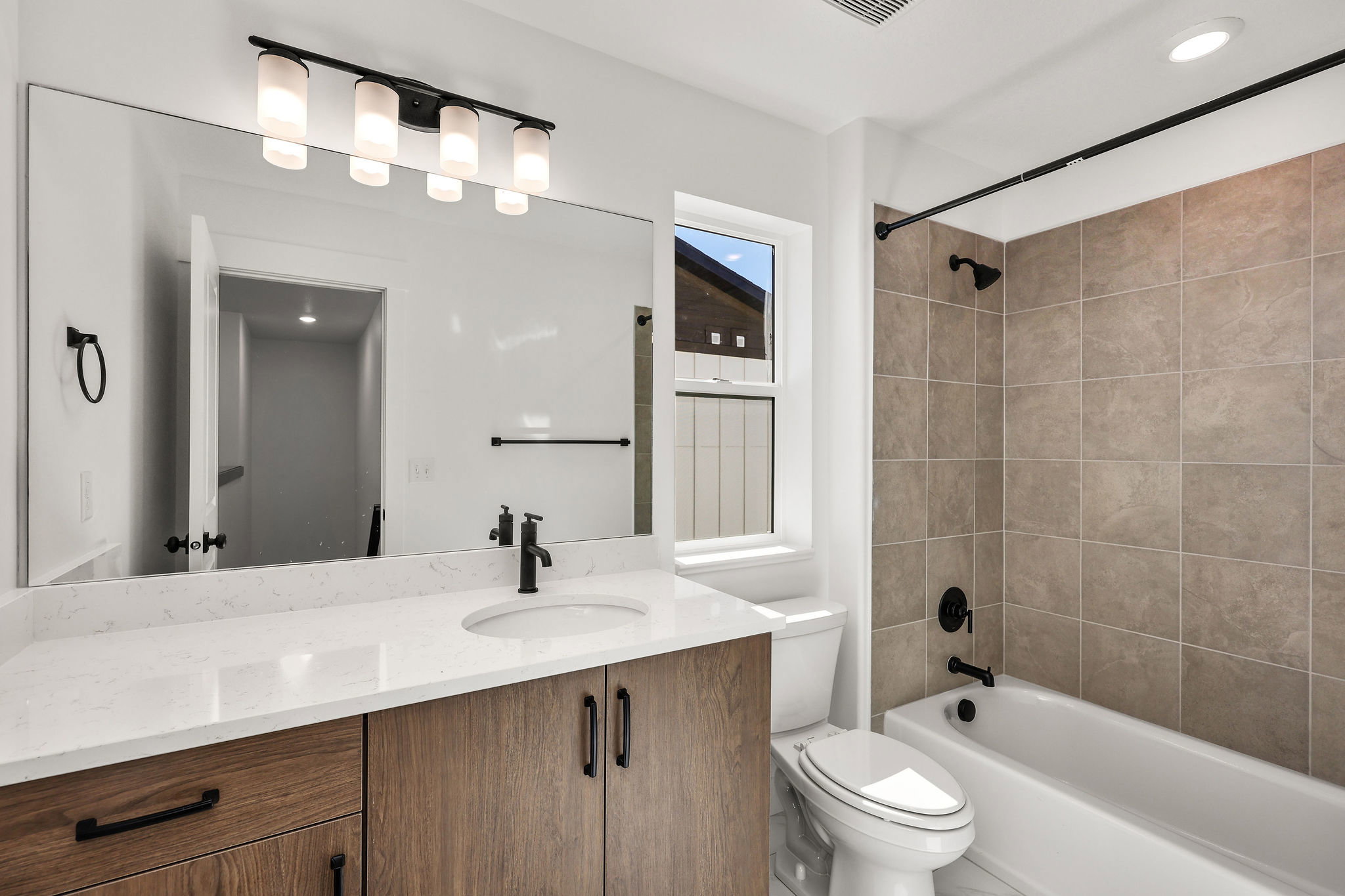 Modern bathroom featuring a wood-finish vanity with a white countertop and rectangular undermount sink