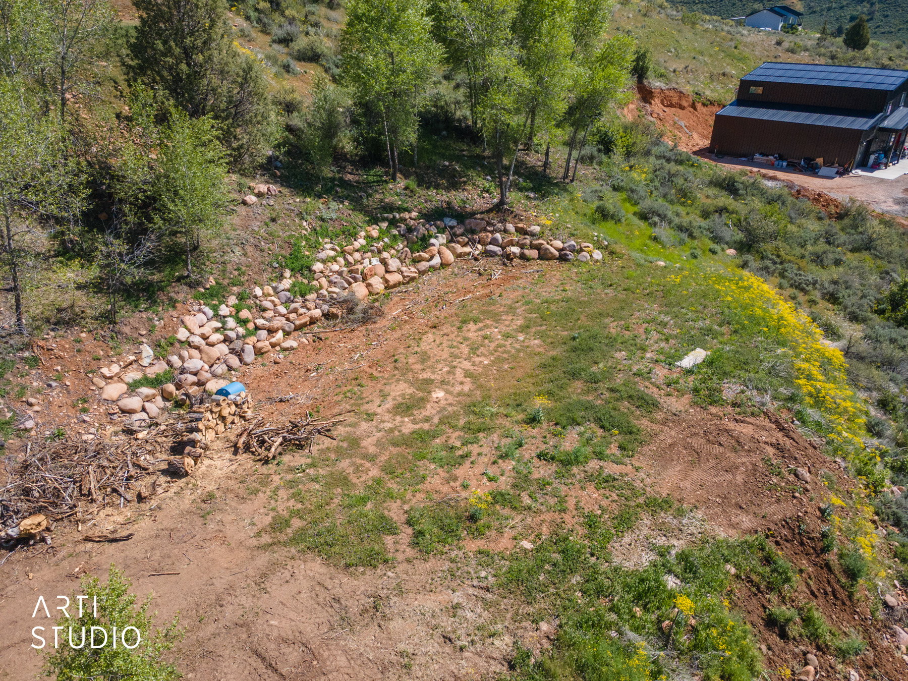 Terraced hillside parcel with a rock retaining wall and natural landscaping