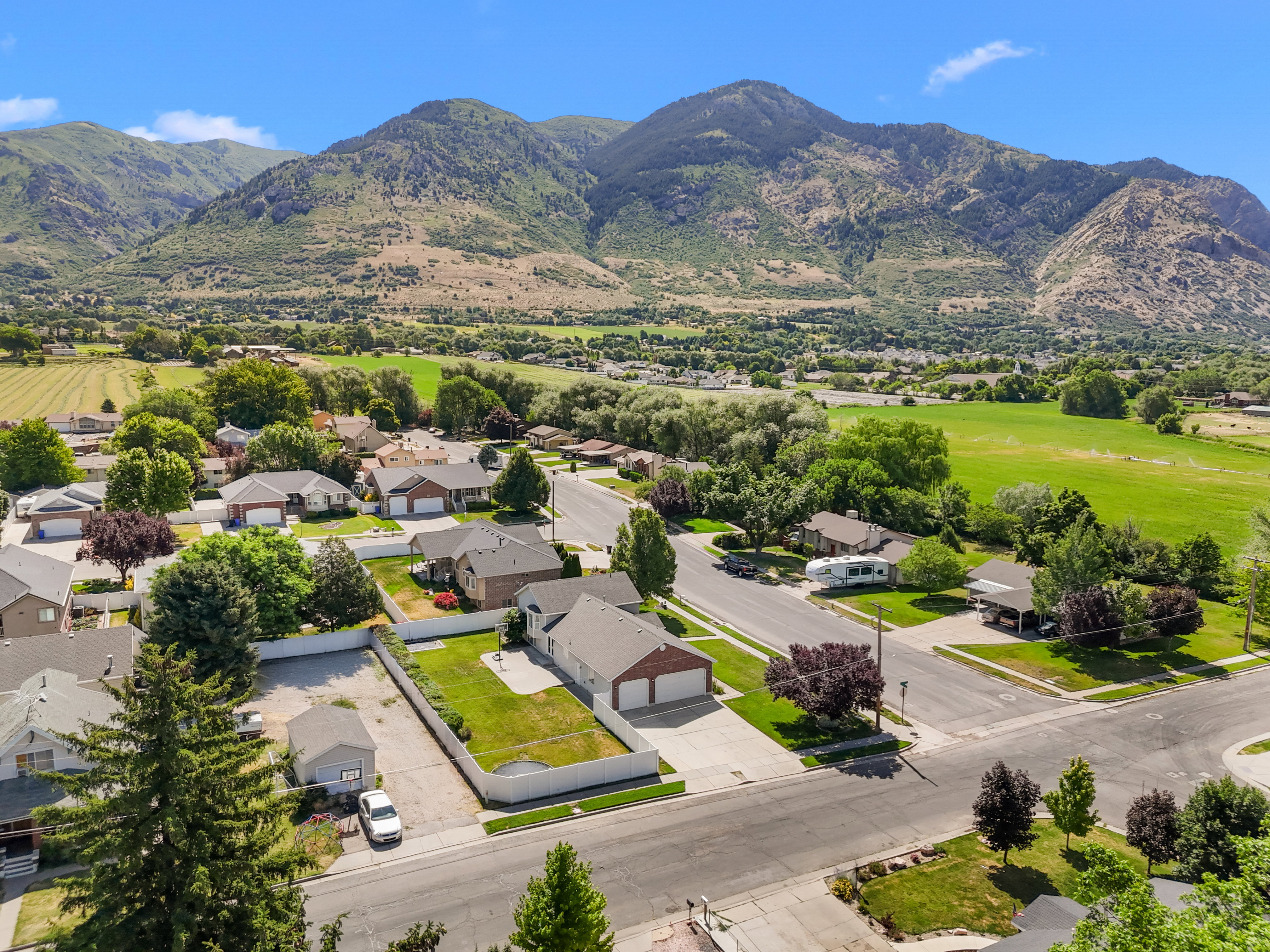 Expansive mountain backdrop framing a residential neighborhood with green fields