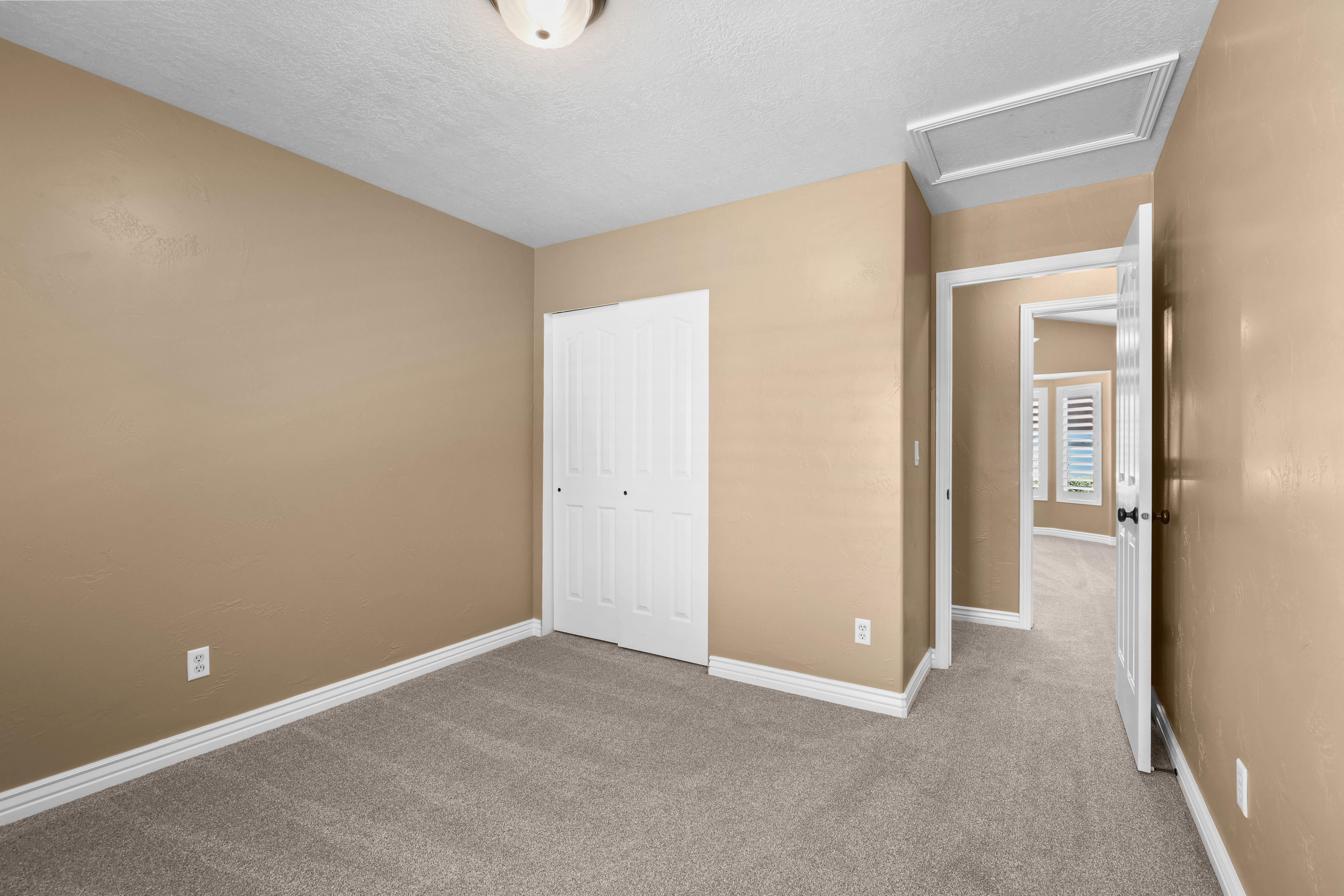 Carpeted room with neutral wall tones and white baseboards