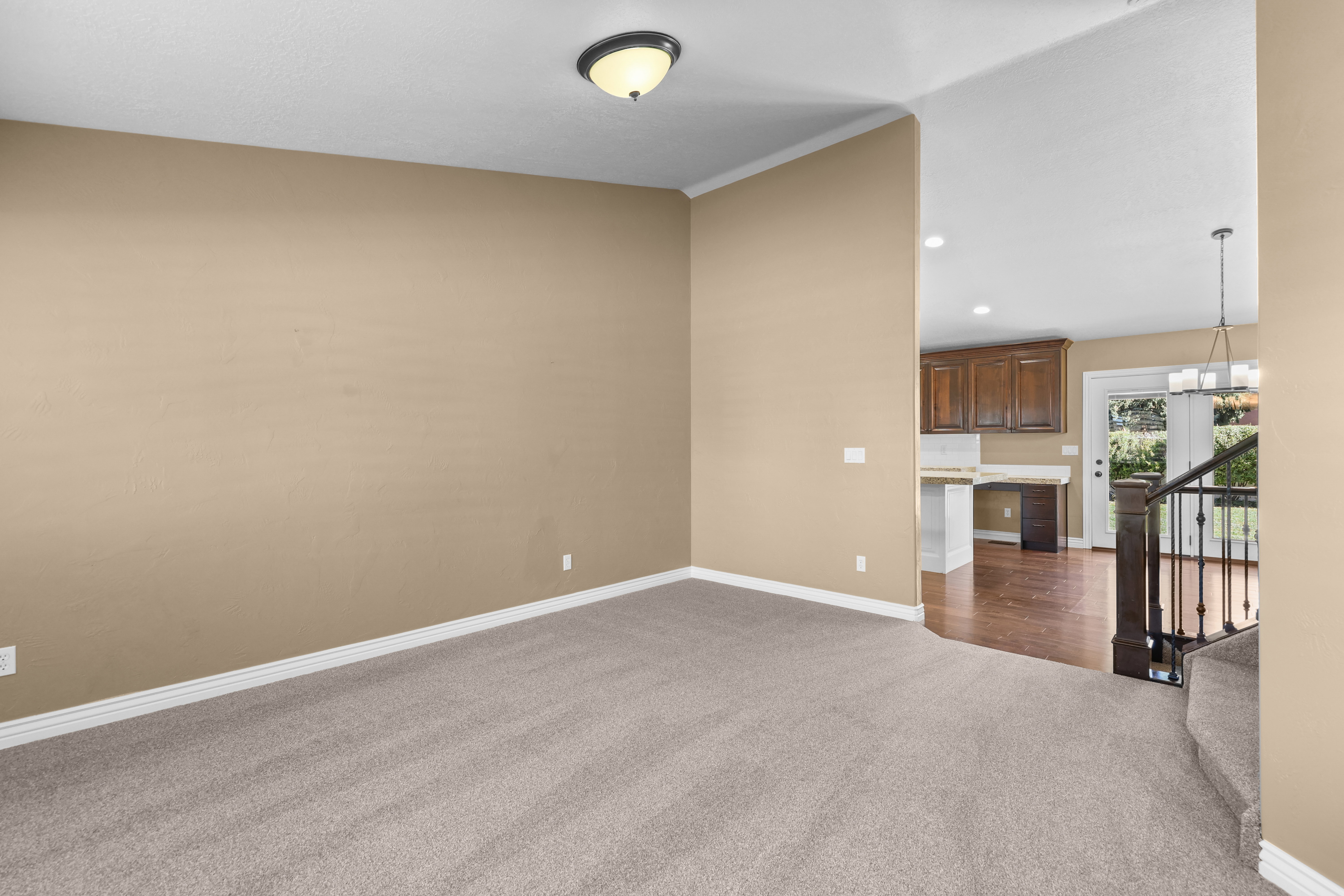 Carpeted room with crown molding, featuring a flush mount ceiling light