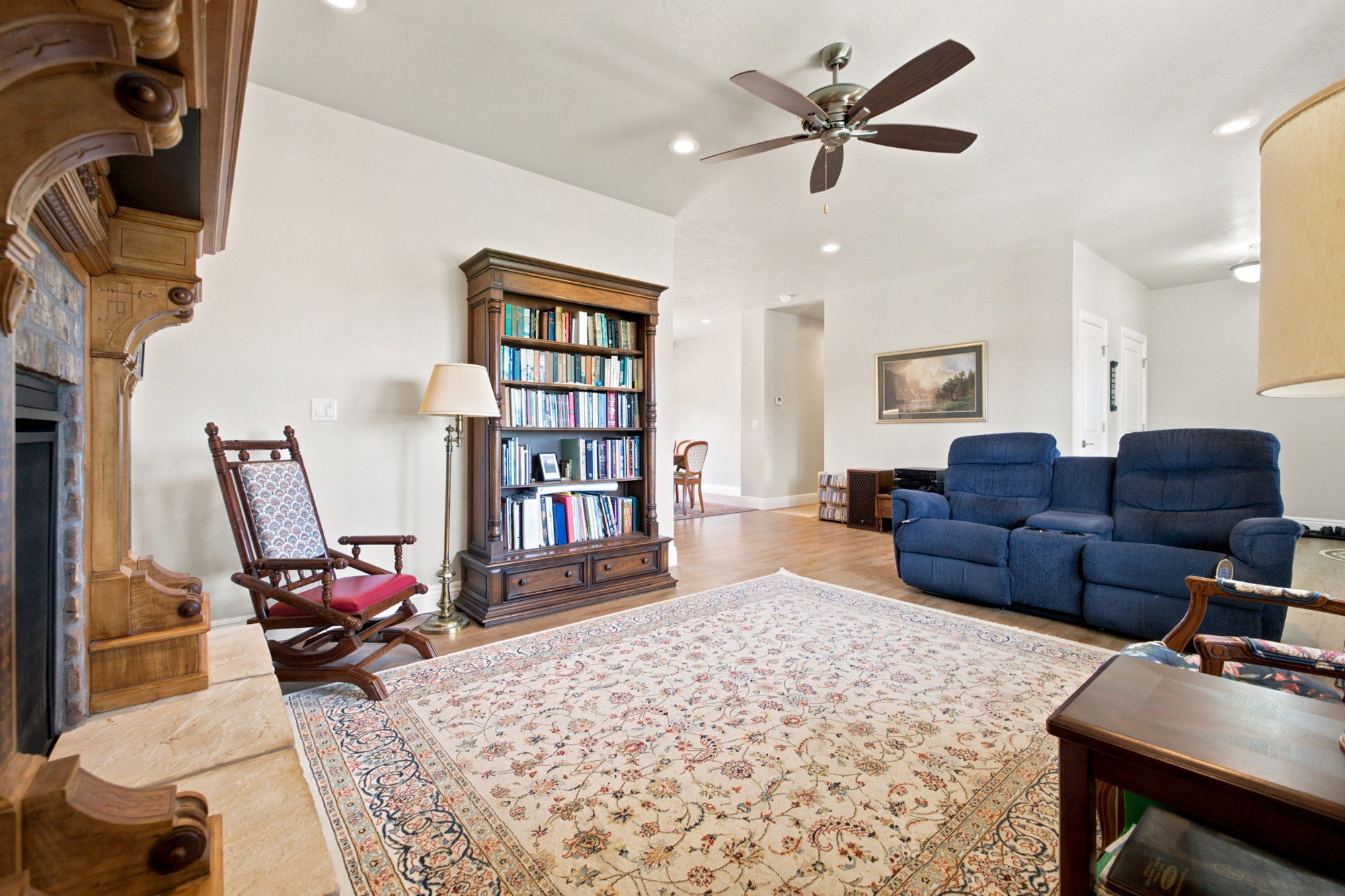 Spacious living area featuring a light wood-finish flooring, and a ceiling fan