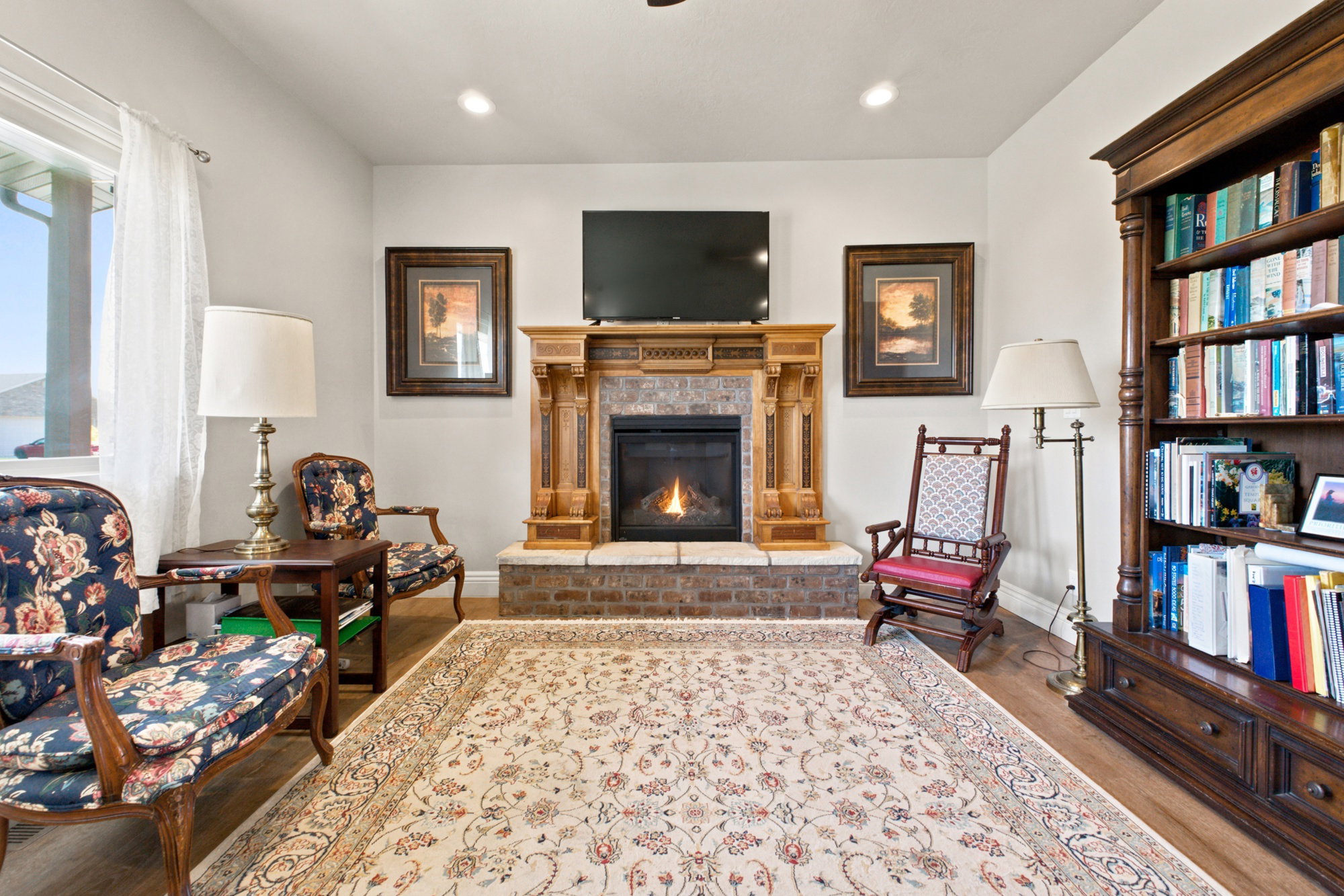 Living area featuring a central fireplace with a wood mantel and tile surround