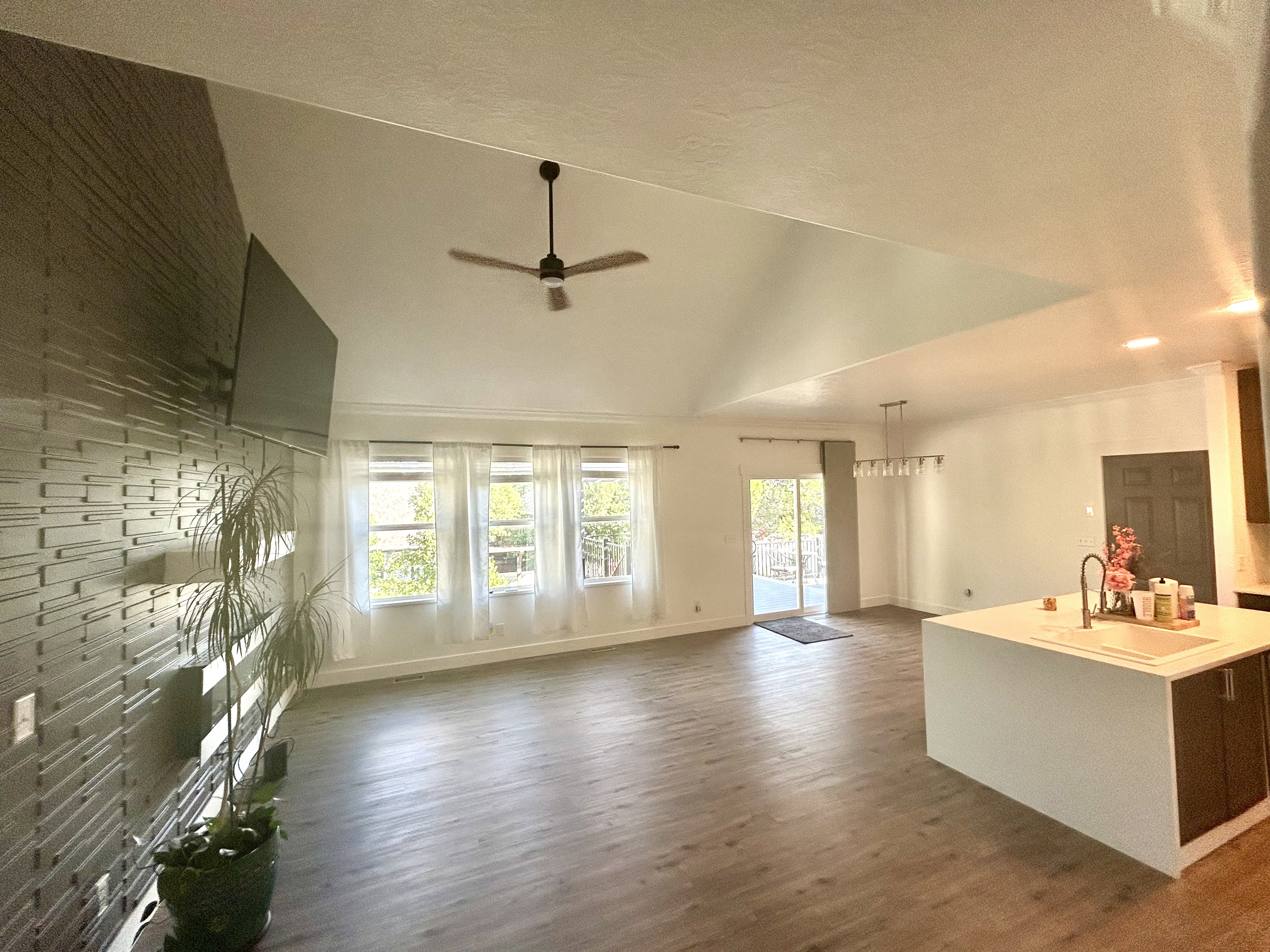 Open-concept living space featuring vaulted ceilings and wood-finish flooring