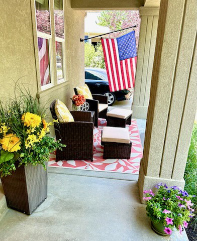 Covered front porch featuring stucco exterior, columned entry, and concrete flooring