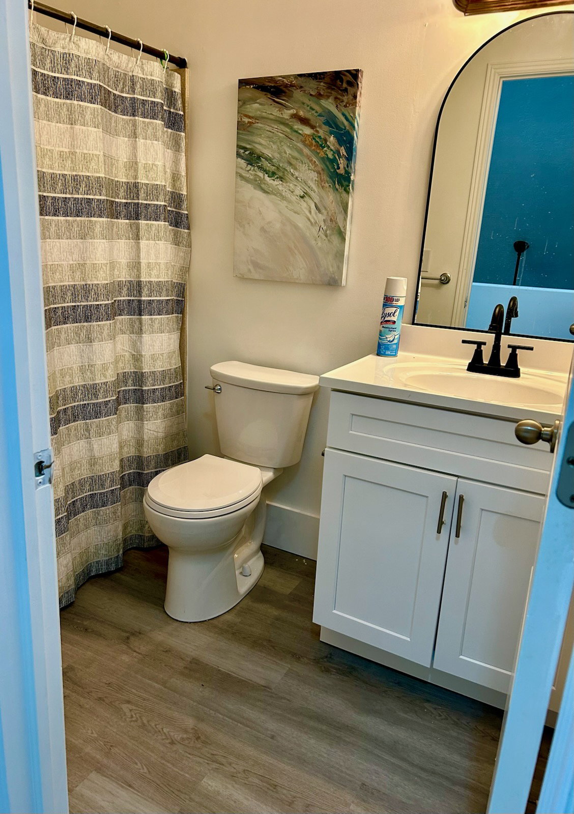 Bathroom featuring wood-finish flooring and a white vanity with shaker-style cabinetry