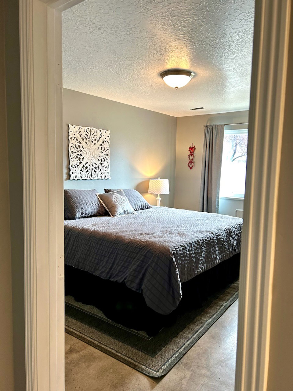 Neutral wall paint with textured ceiling finish, recessed lighting, window with drapes, and durable flooring