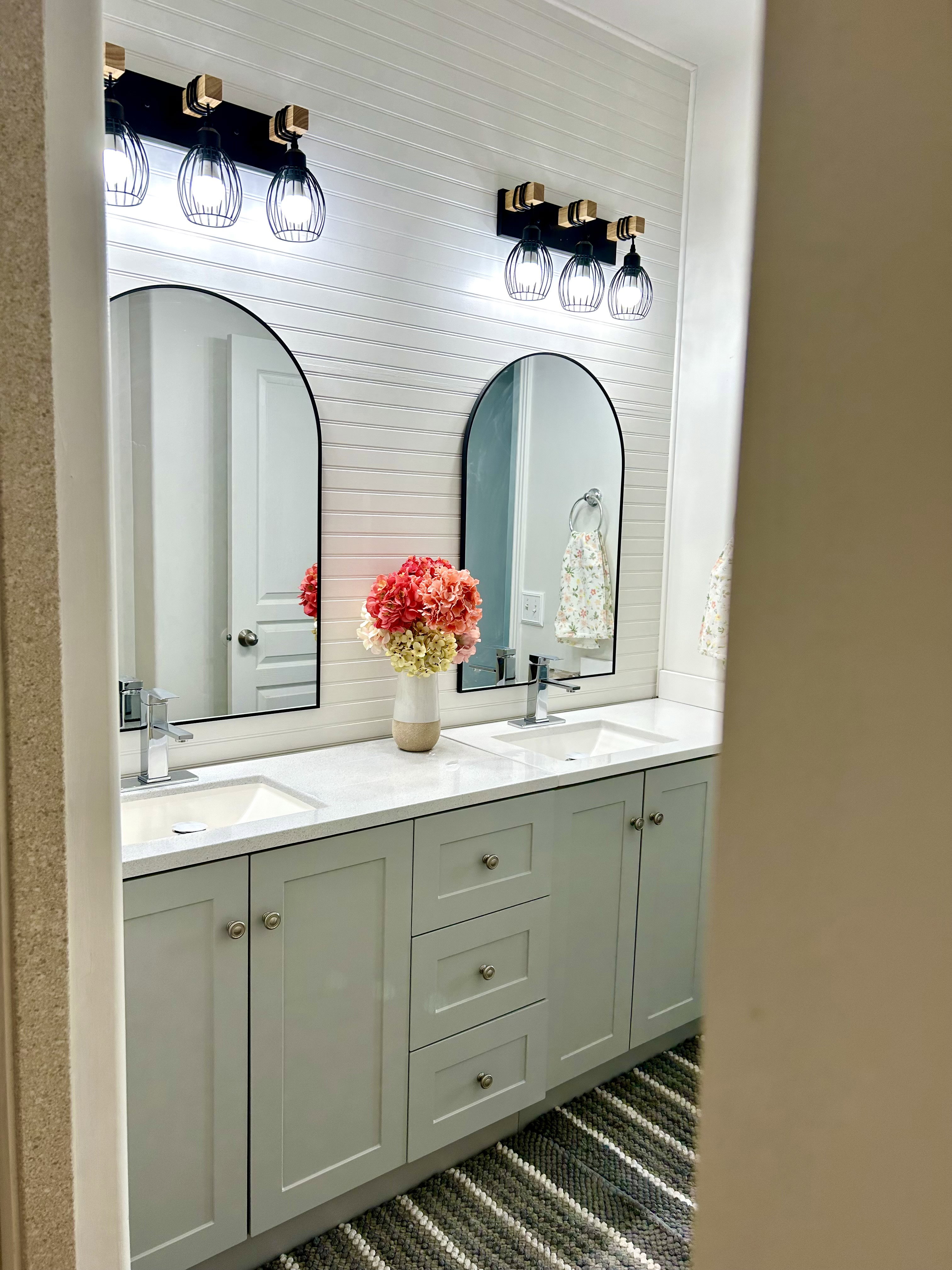 Double vanity featuring light gray cabinetry, integrated sinks, chrome faucets, and white countertops