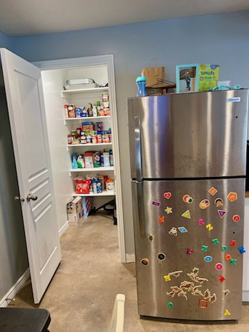 Walk-in pantry with white shelving, offering extensive storage capacity