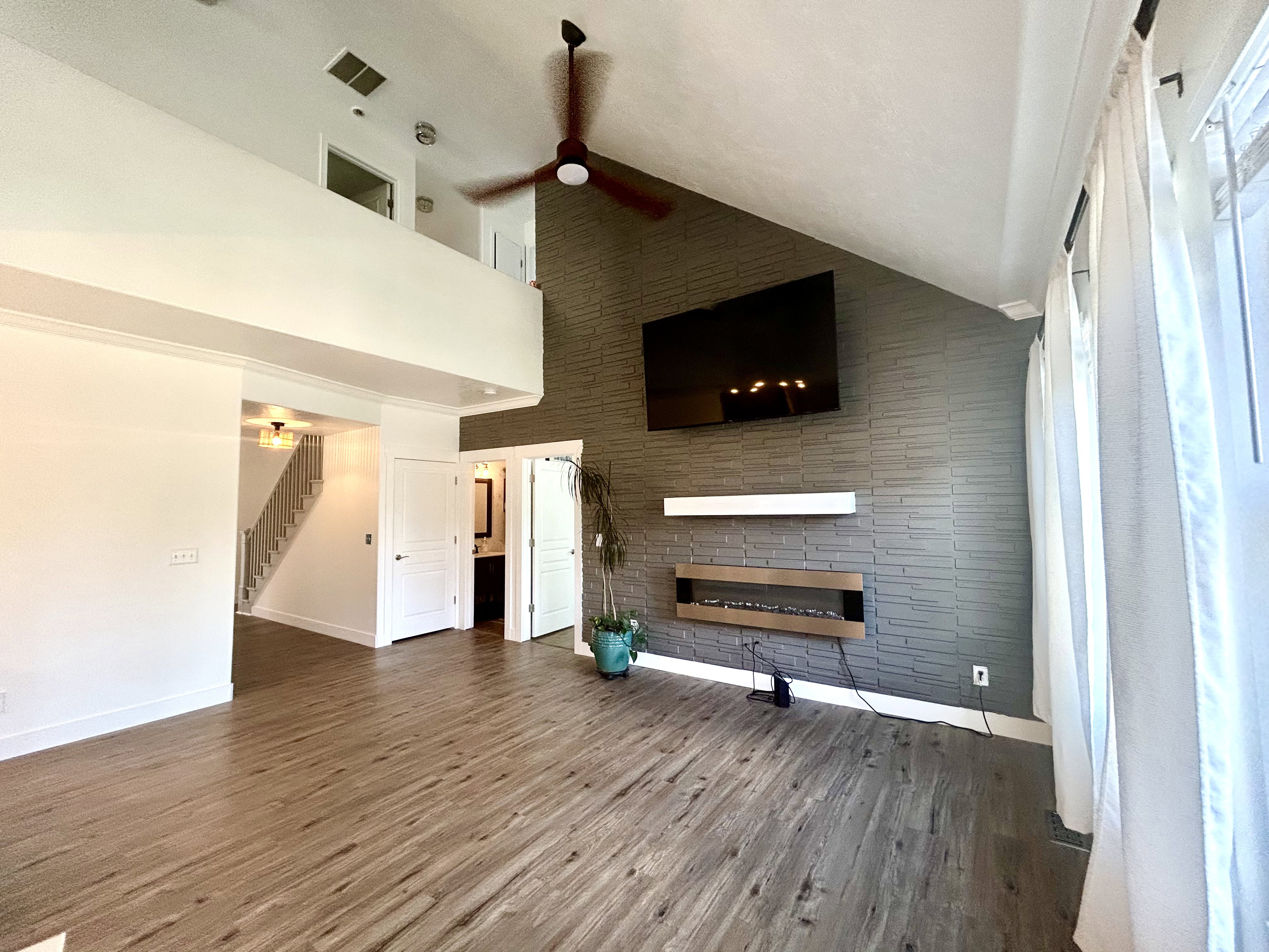 Spacious interior featuring wood-finish flooring and a vaulted ceiling