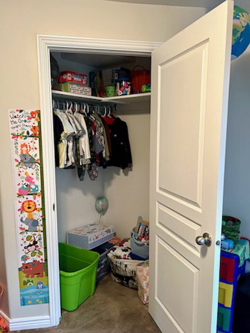 Walk-in closet featuring white interior walls, white wire shelving, and a built-in hanging rod