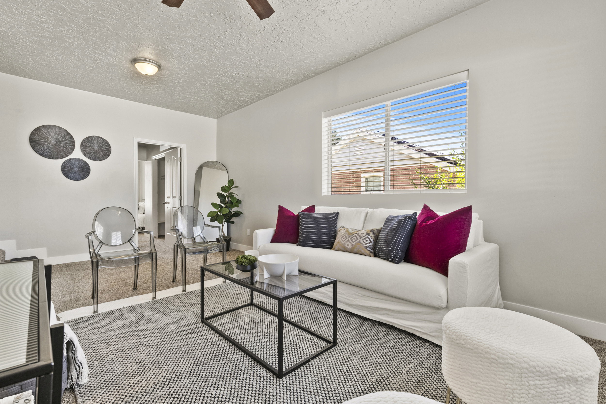 Bright room featuring a ceiling fan, recessed lighting, and a large window with horizontal blinds