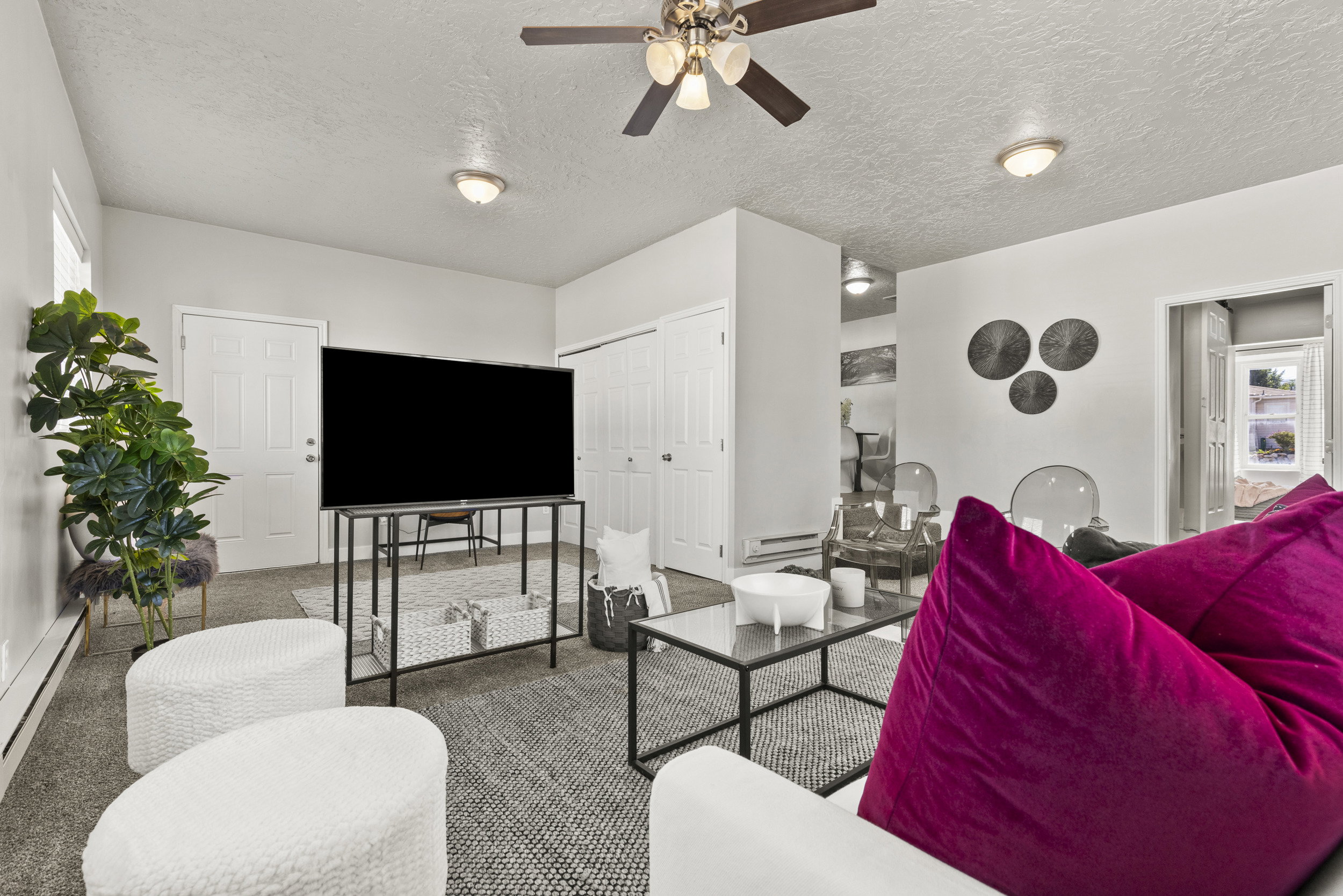 Bright living area featuring textured carpeting, neutral wall tones, and recessed lighting