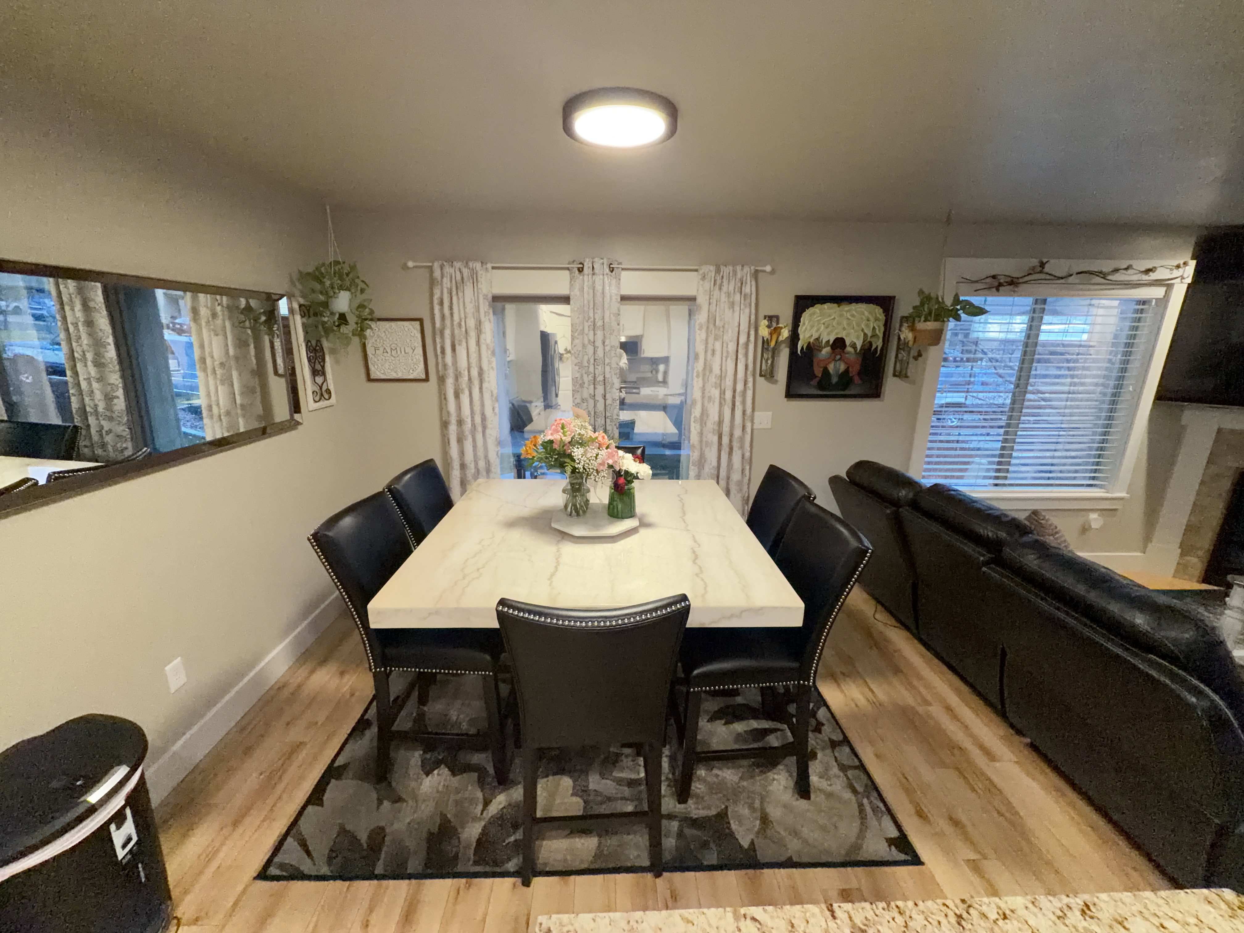 Dining area featuring wood-finish flooring and a contemporary overhead light fixture