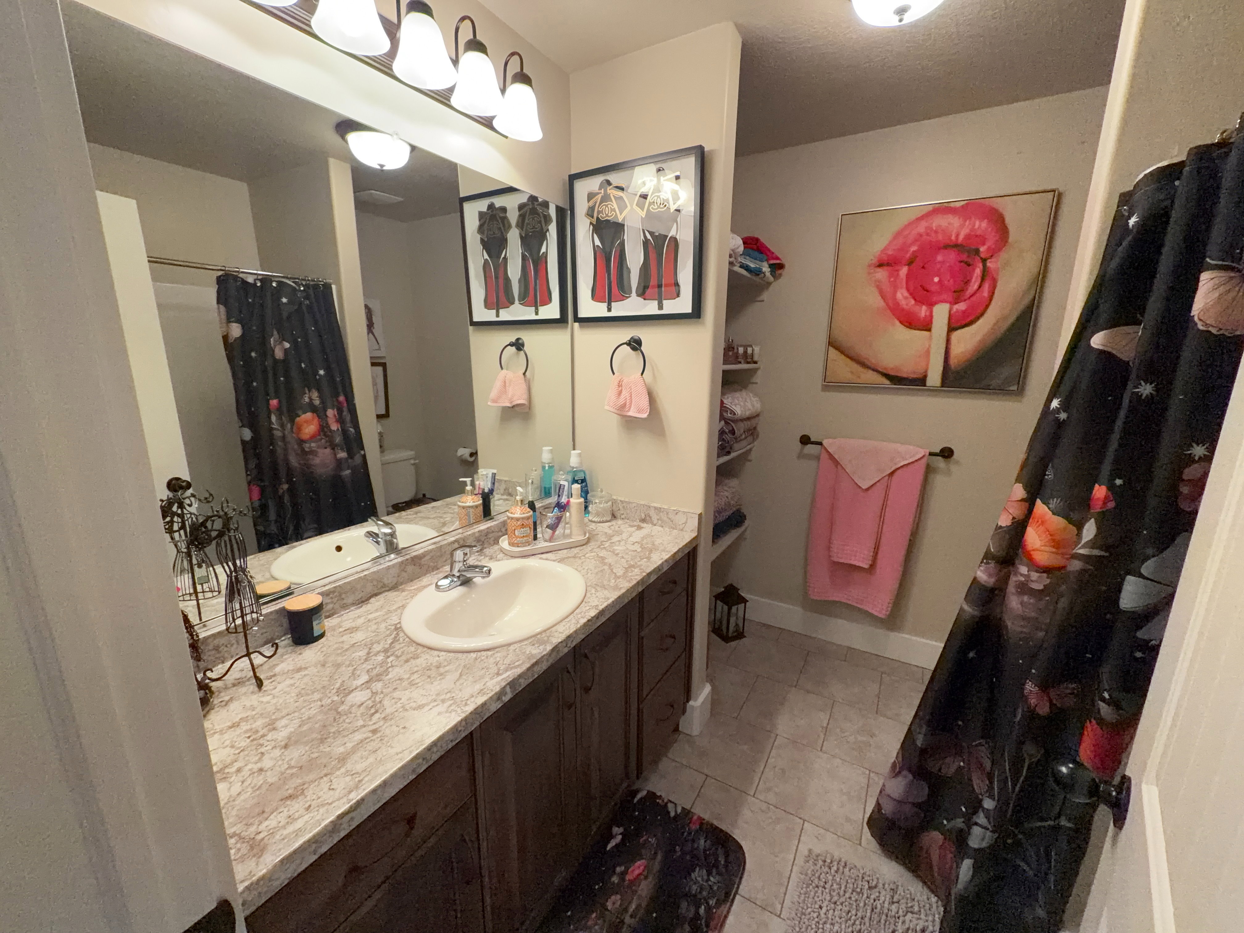Bathroom featuring a double vanity with a patterned countertop and white oval sinks