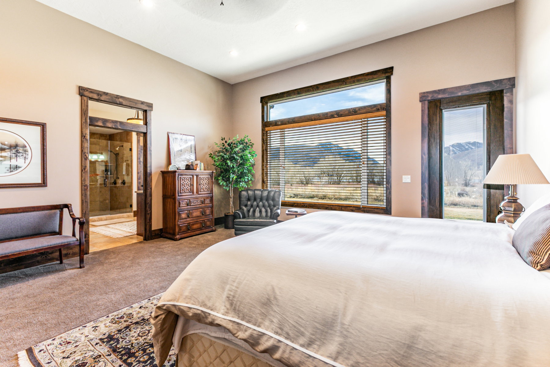Carpeted interior space featuring extensive window and door framing, a large glass pane window with blinds, a glass pane door, and a recessed ceiling light