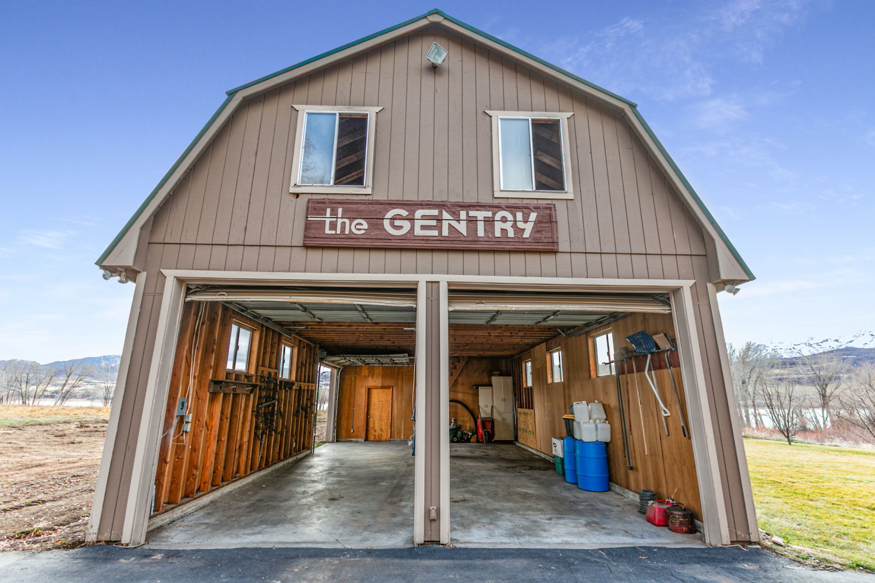 Two-bay garage structure with a gambrel roof and upper-level windows