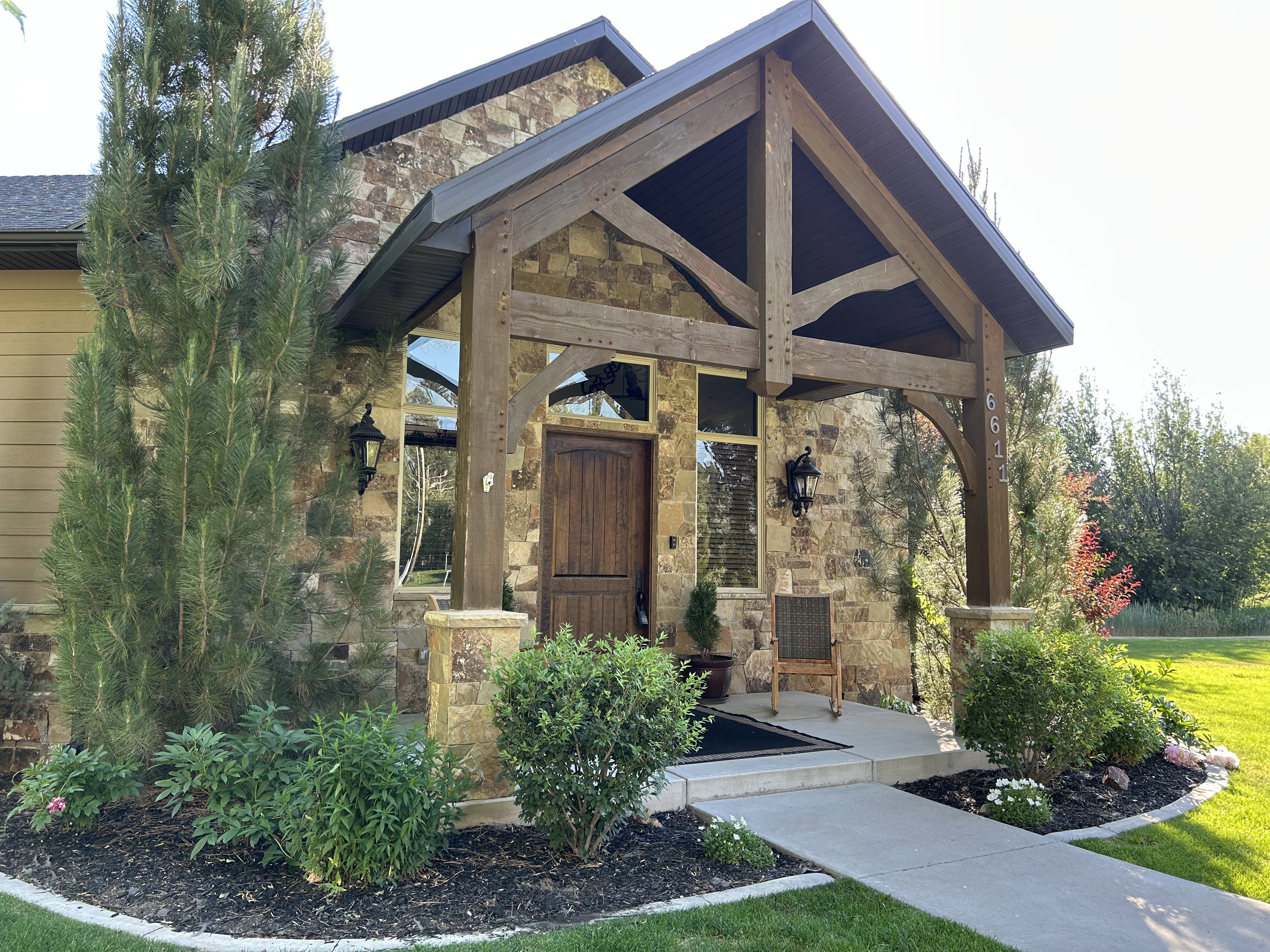 Stone facade exterior with a prominent timber-frame entry portico