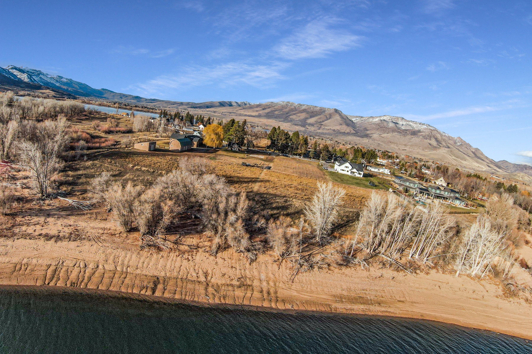 Expansive waterfront property featuring a substantial land parcel, direct water access, mountainous terrain, and multiple structures