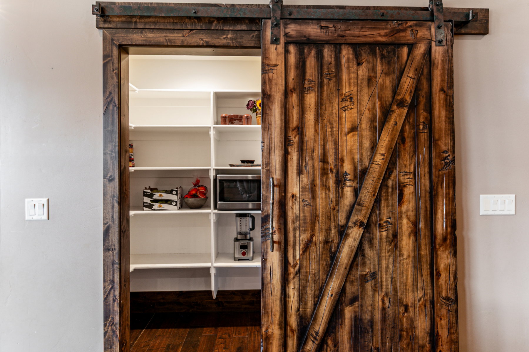 Sliding barn door with dark wood finish and exposed metal hardware