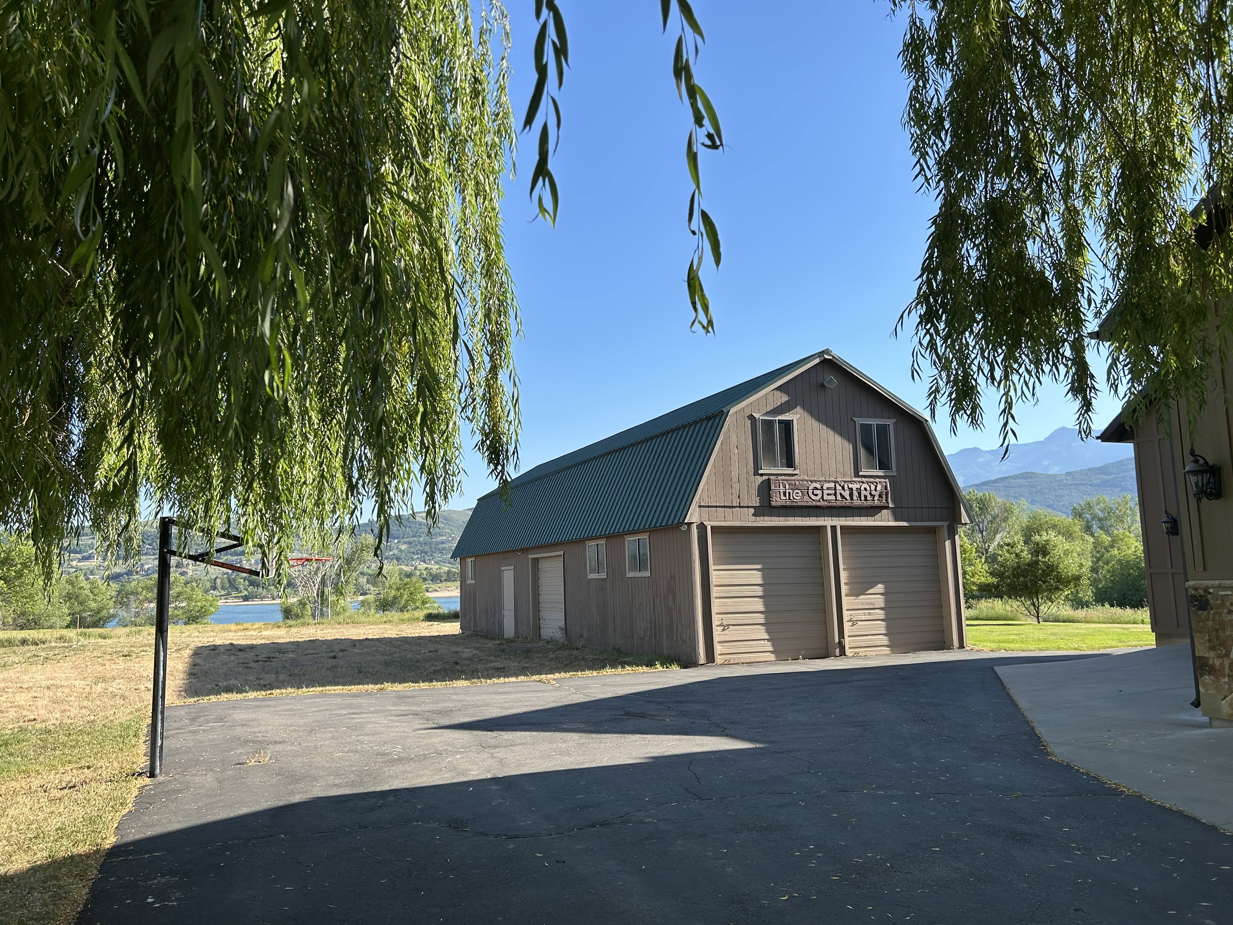 Barn structure featuring a green metal gambrel roof and two garage doors