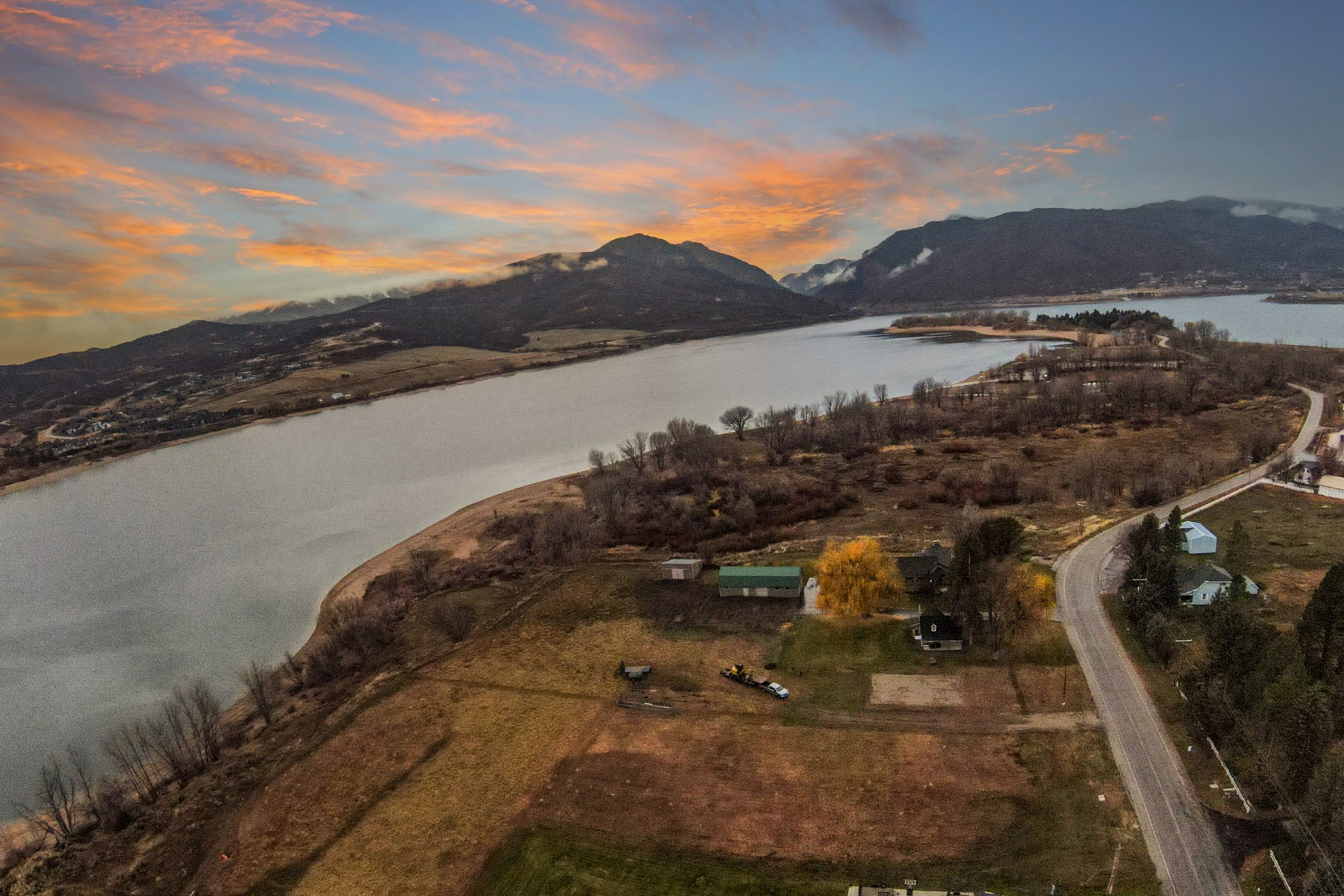 Expansive waterfront property featuring a substantial land parcel, mature trees, and direct water frontage