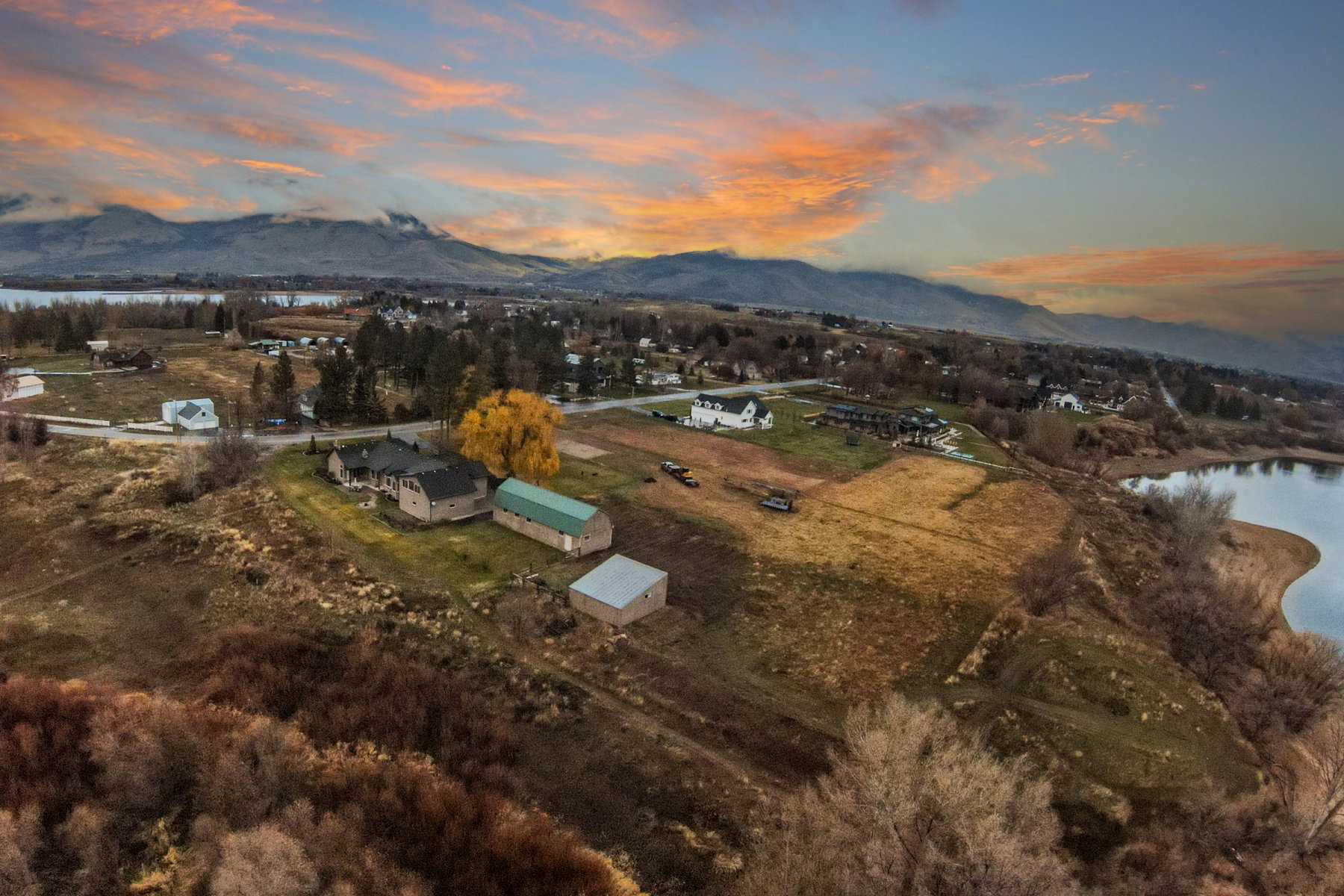 Expansive acreage featuring multiple structures, including a primary residence, a large green barn, and a smaller outbuilding