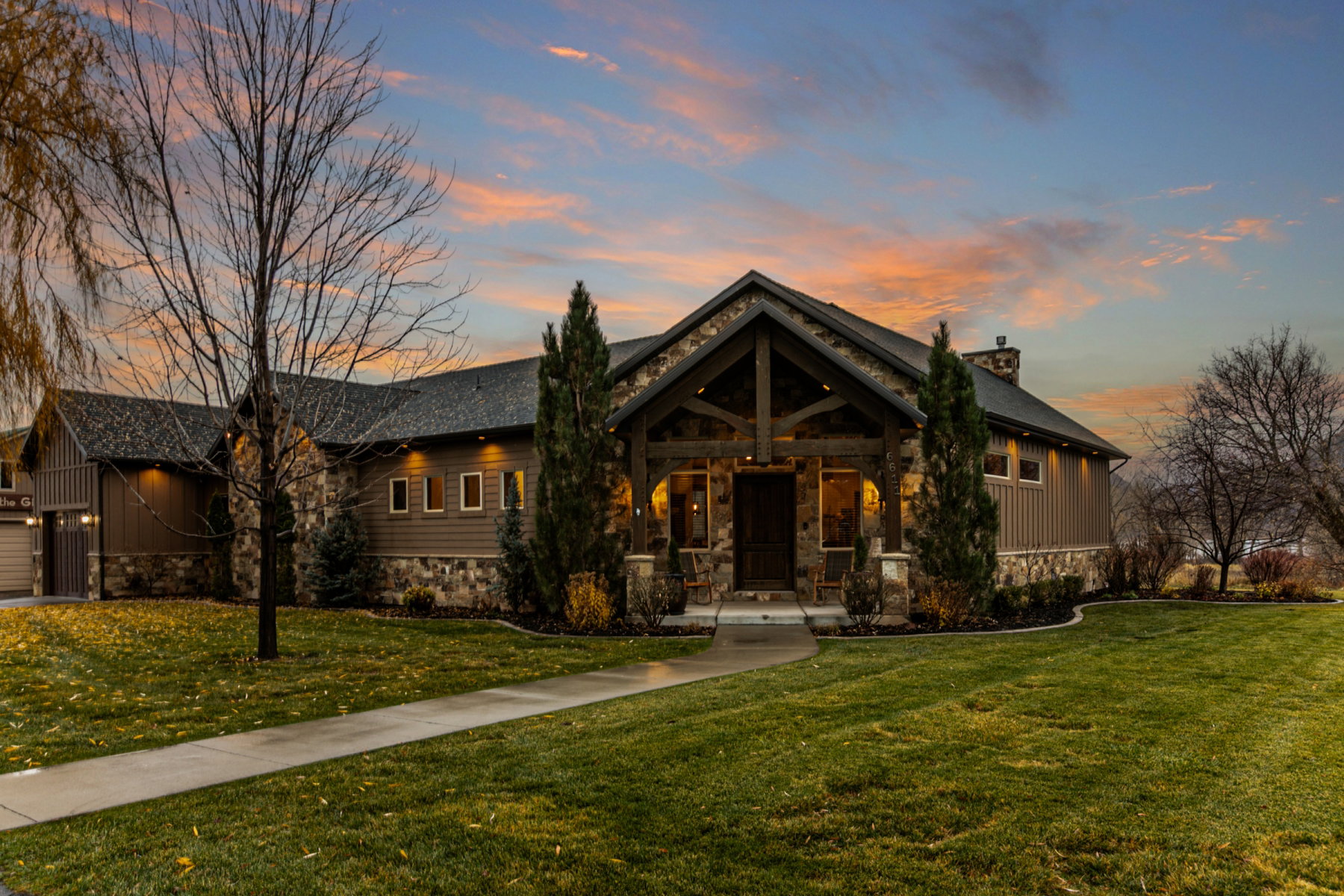 Stone and siding exterior with a prominent gabled entry featuring exposed timber beams