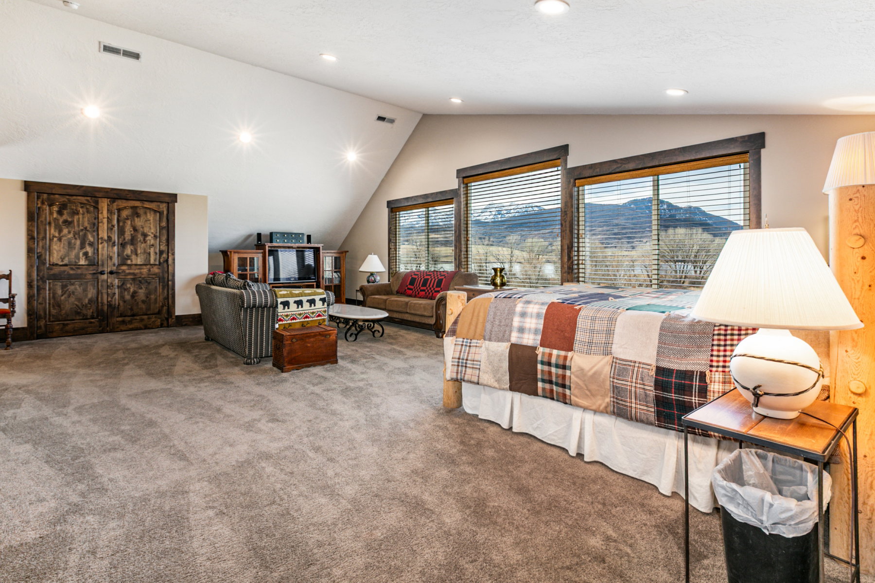 Spacious room featuring broadloom carpeting and multiple large windows with mountain scenery