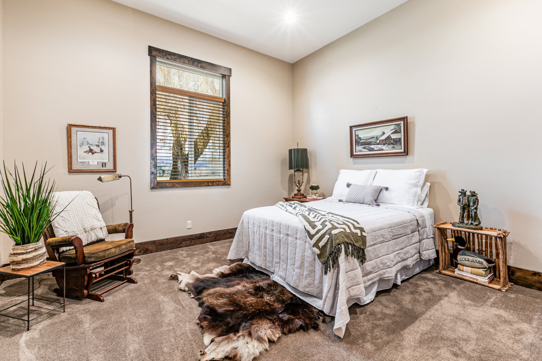 Neutral tone walls with wood trim, large window with blinds, and carpeted flooring