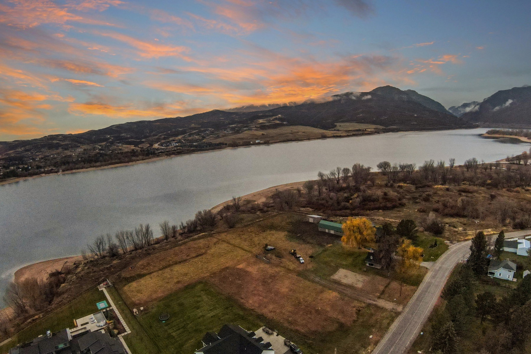 Expansive waterfront property featuring a substantial land parcel, direct water access, and mature trees