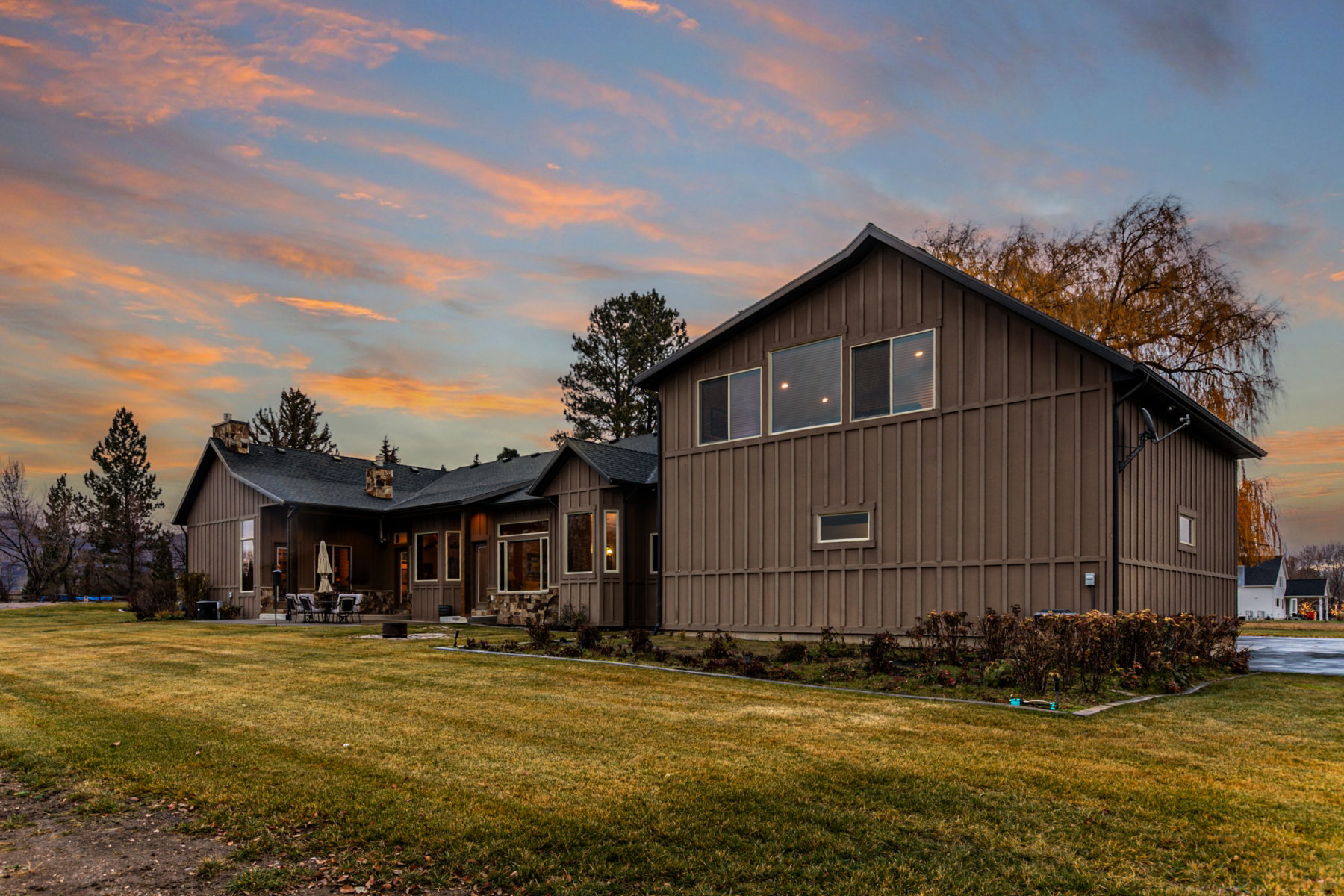 Expansive property featuring a brown board and batten exterior and a dark shingle roof