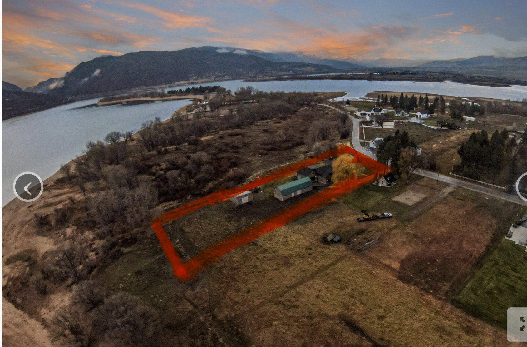 Aerial property overview featuring a main structure, a green-roofed outbuilding, and a prominent yellow tree